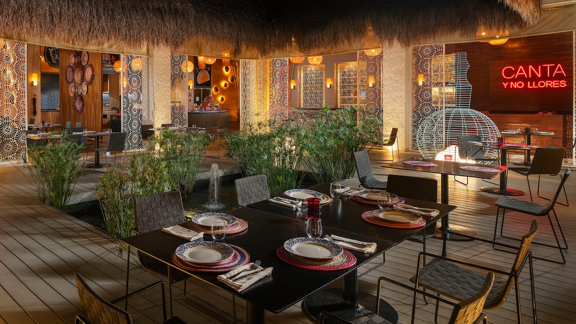 a table set for dinner with a fountain in the background