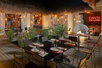 a table set for dinner with a fountain in the background