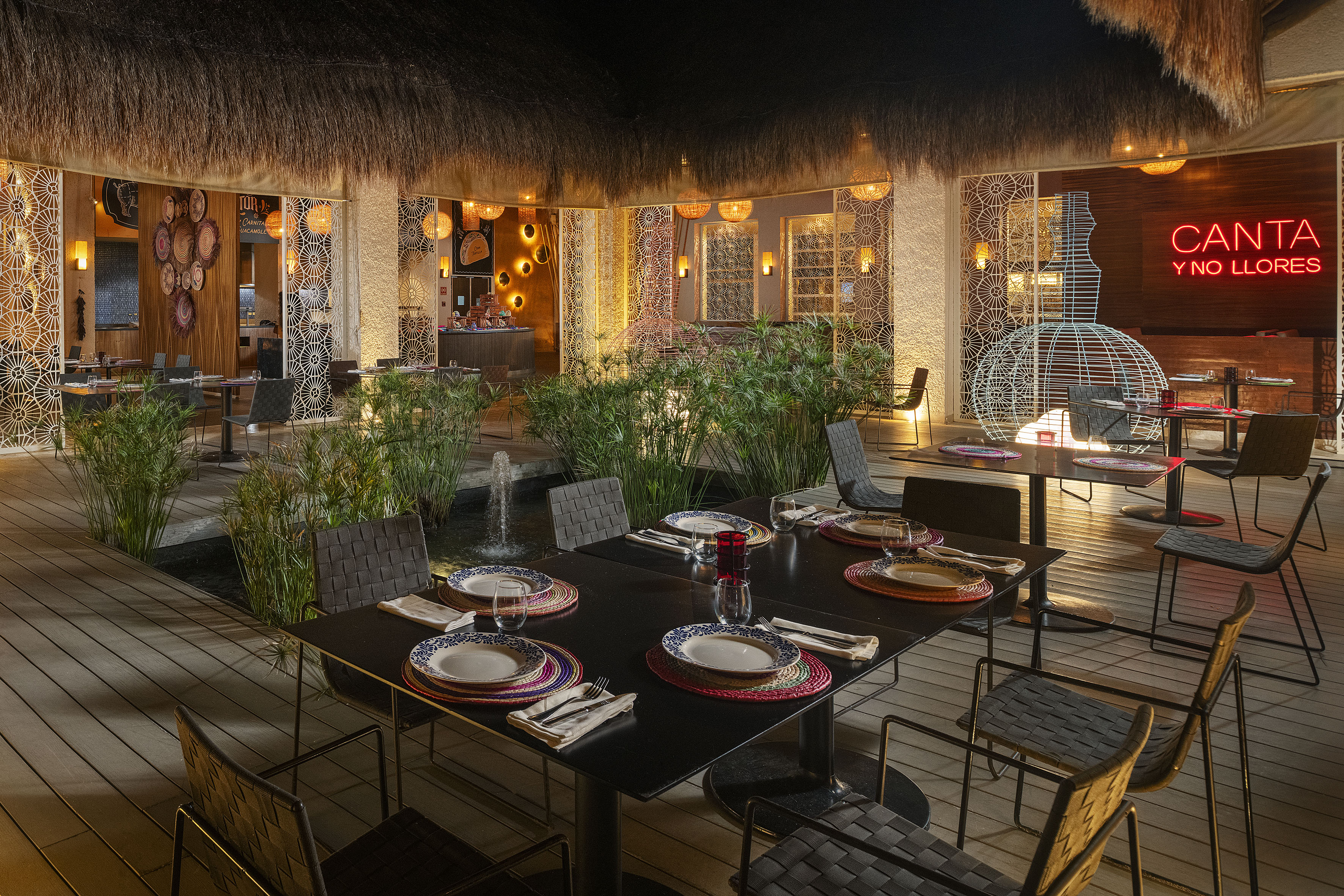 a table set for dinner with a fountain in the background
