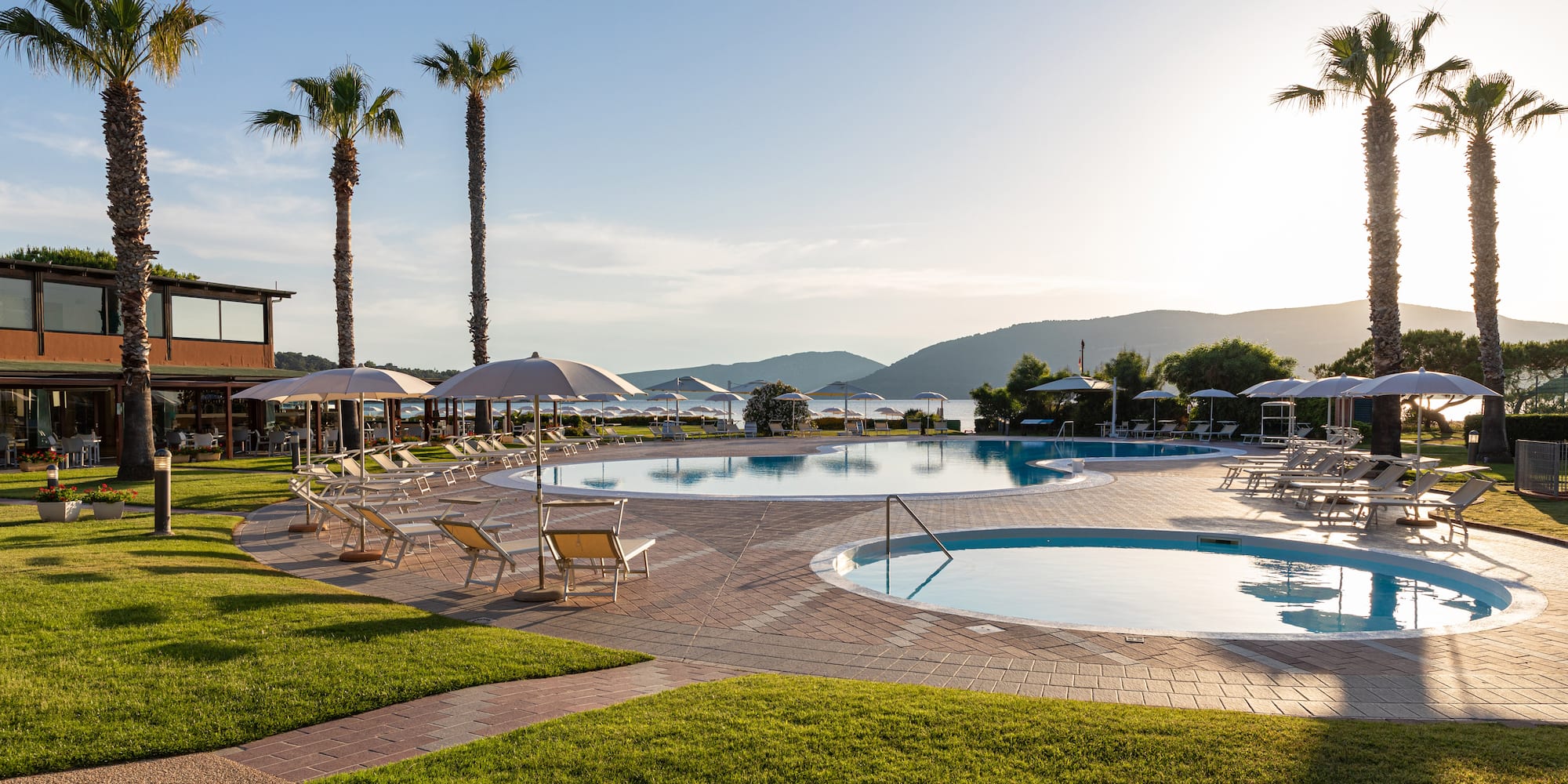 a pool with umbrellas and chairs and palm trees