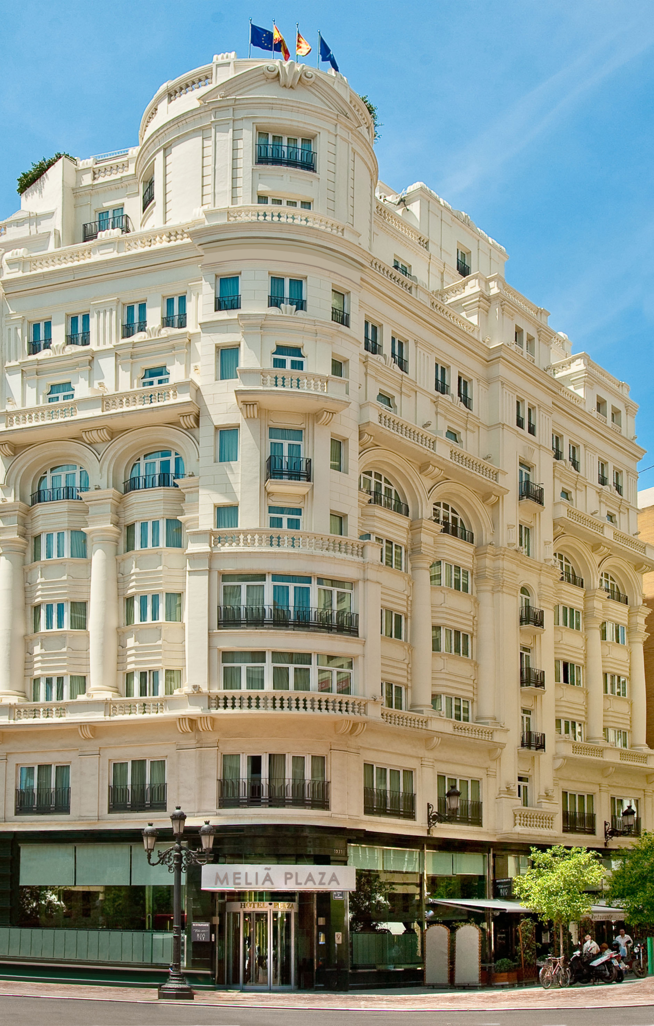 Ornate white Meliá Plaza hotel building with classical architecture and flags.