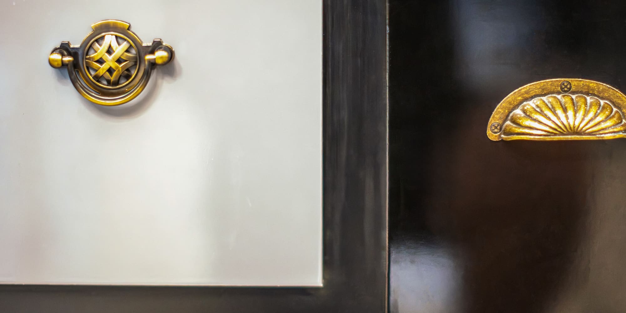 a black and white cabinet with gold handles