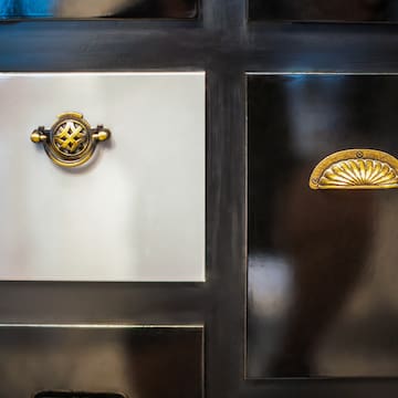 a black and white cabinet with gold handles