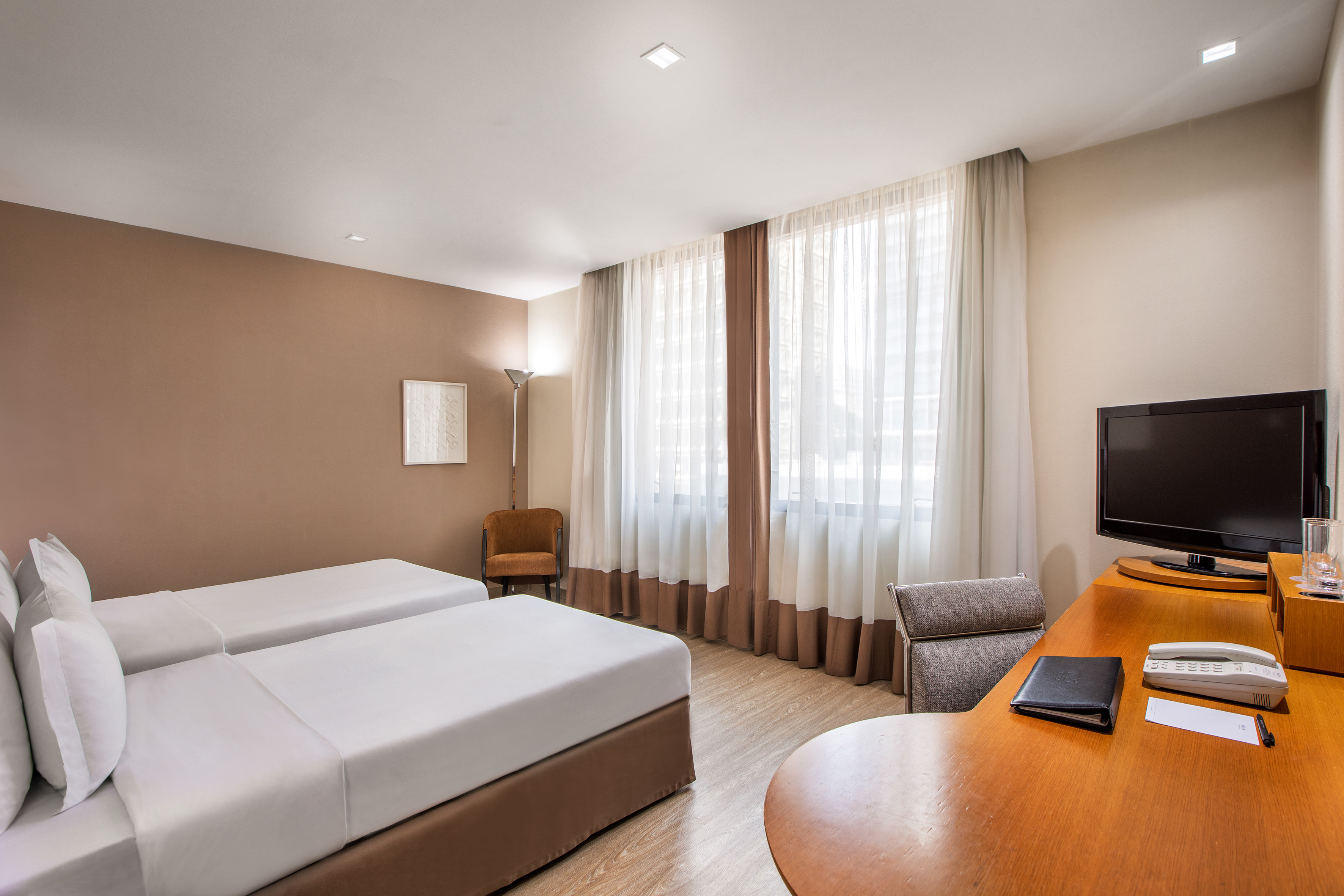 a room with two beds and a desk