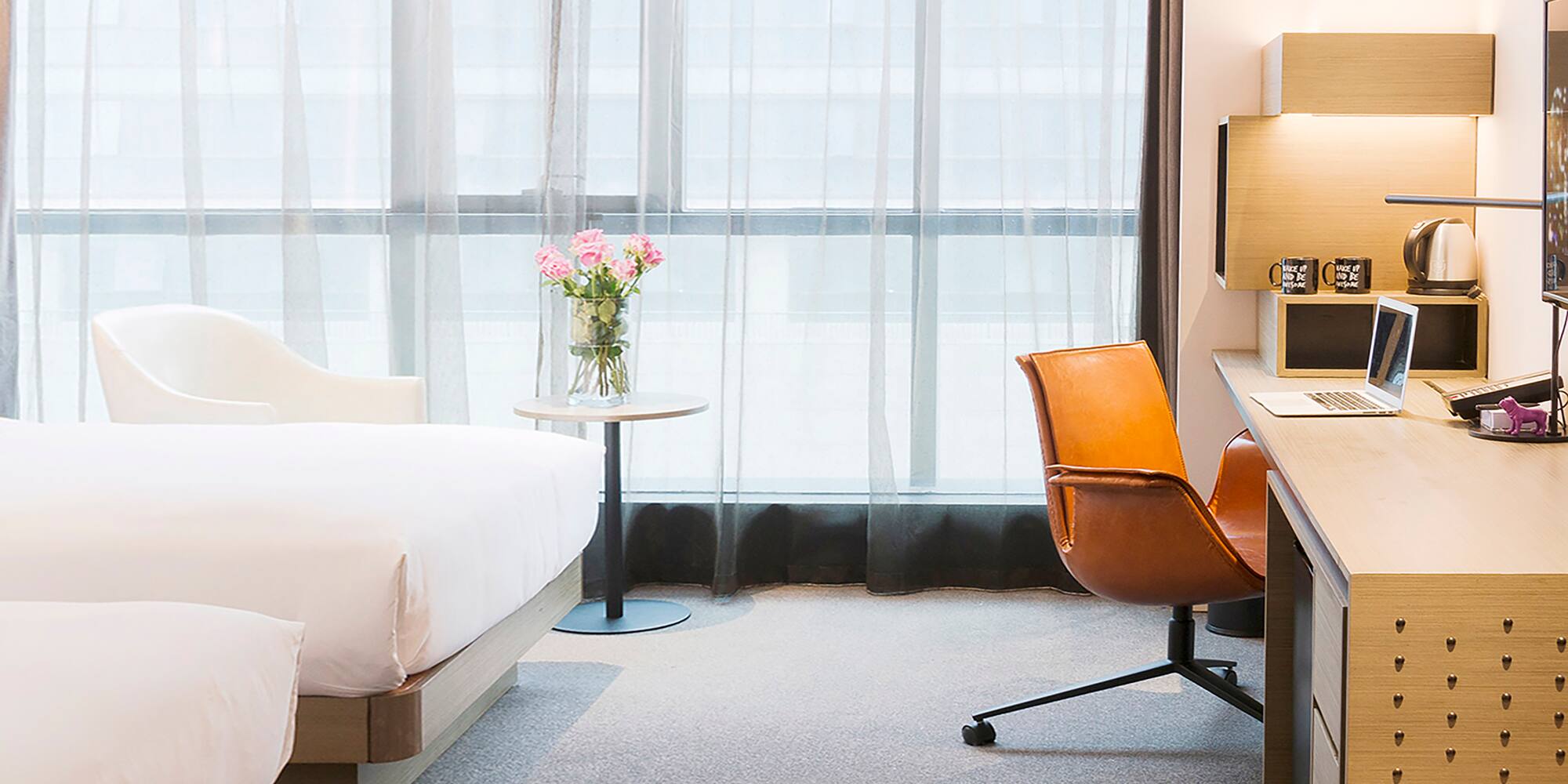 a room with a bed and a vase of flowers