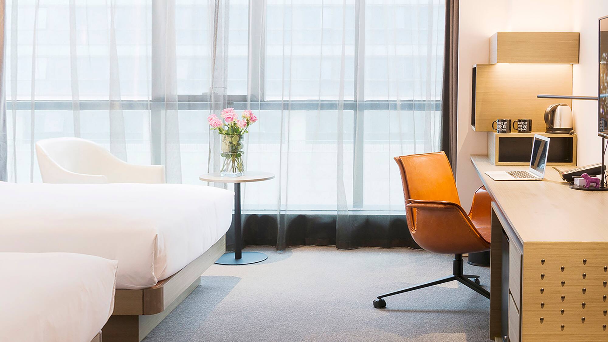 a room with a bed and a vase of flowers