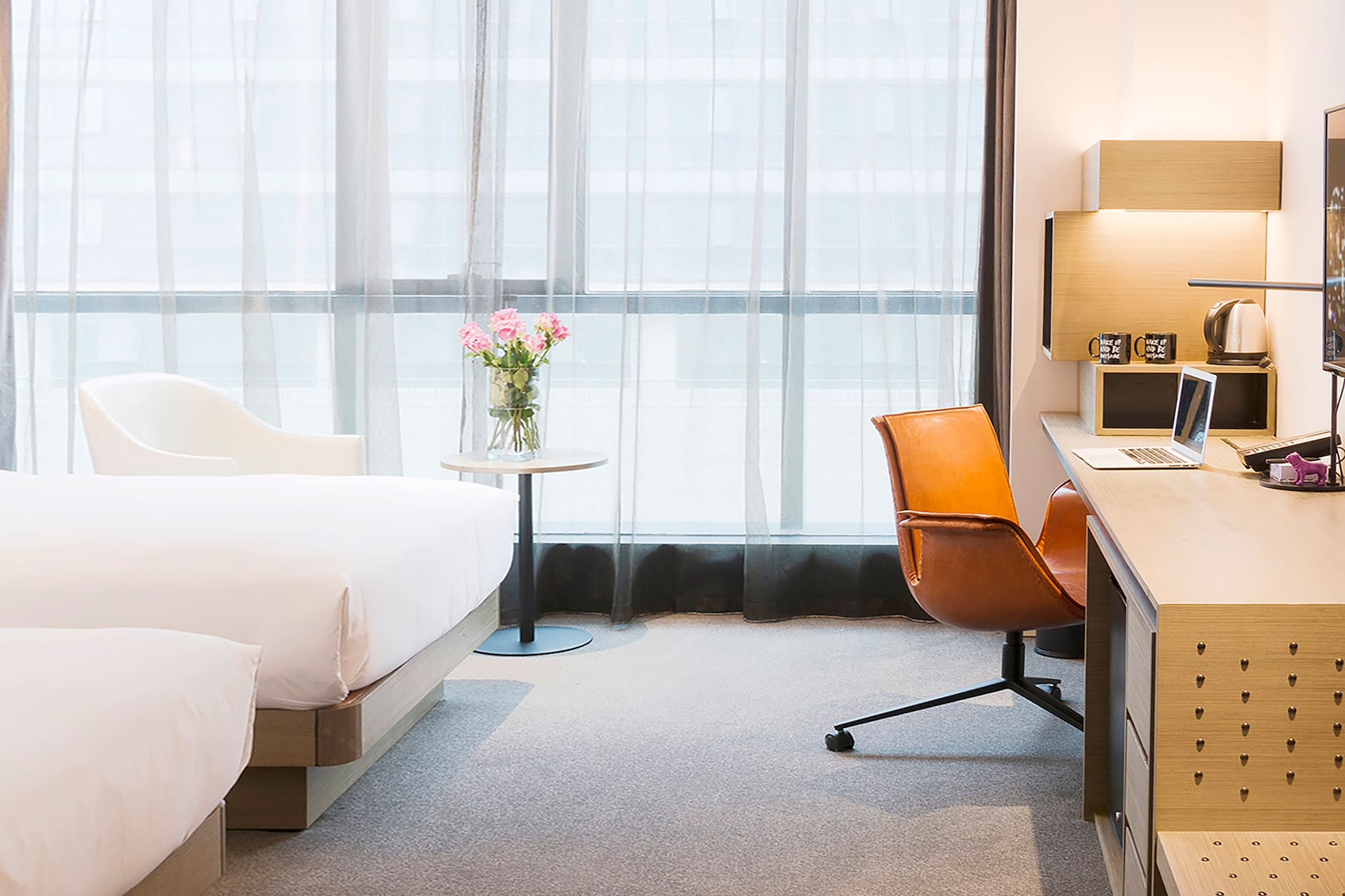 a room with a bed and a vase of flowers