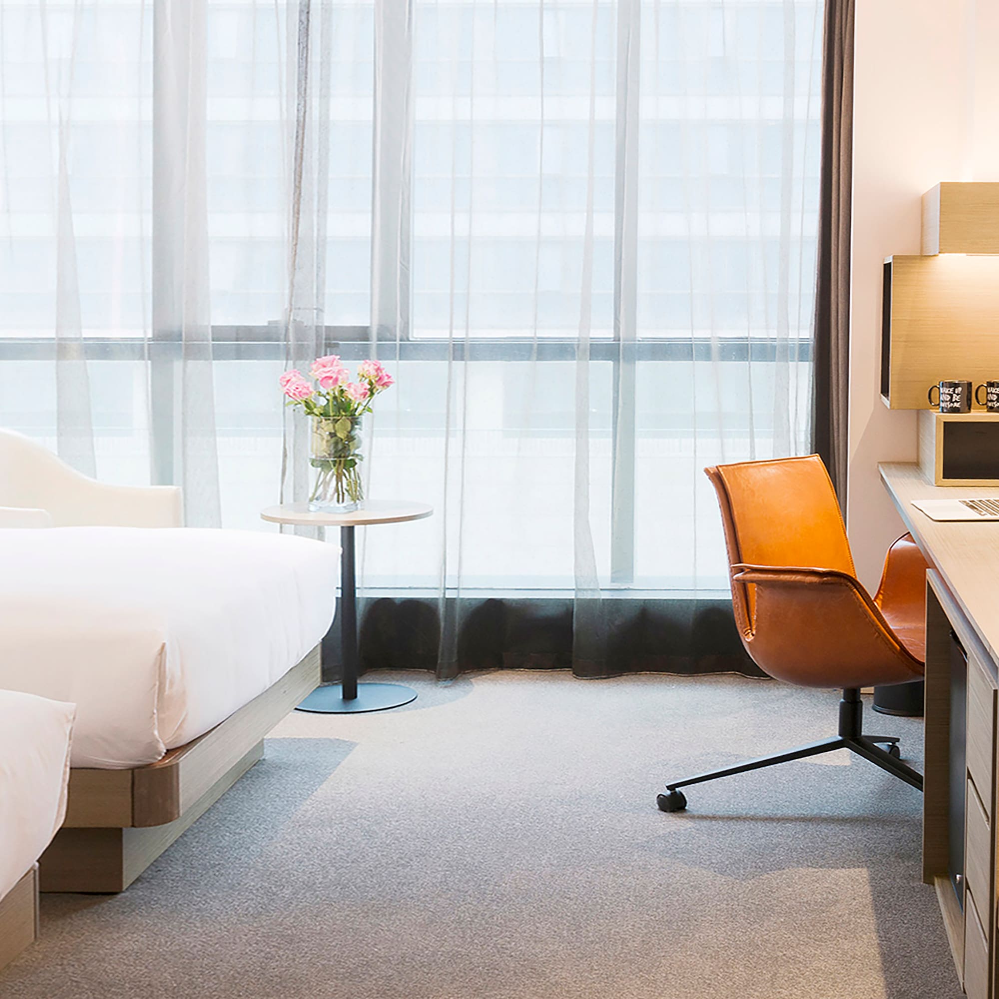 a room with a bed and a vase of flowers