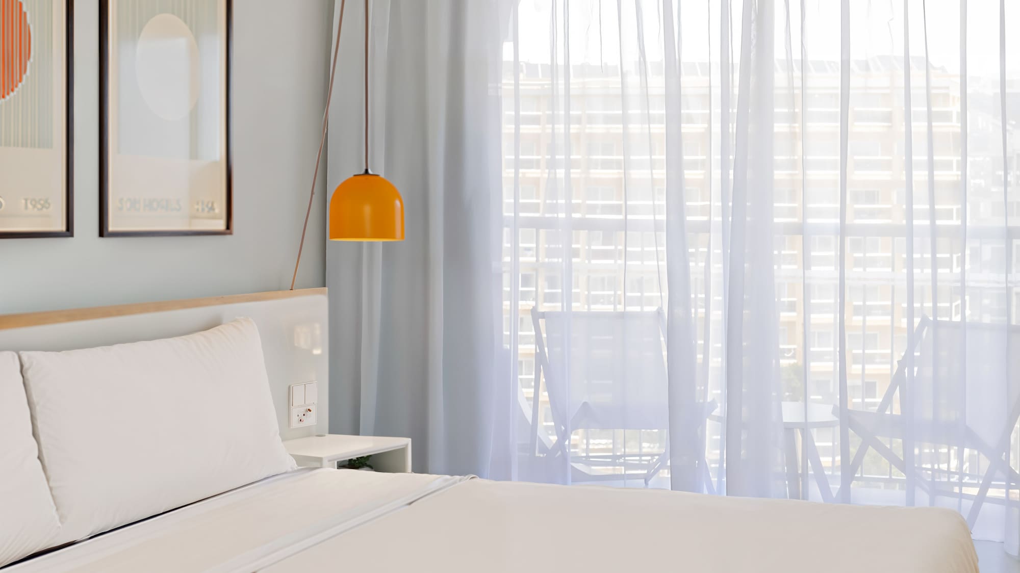 a bed with a lamp and pictures on the wall