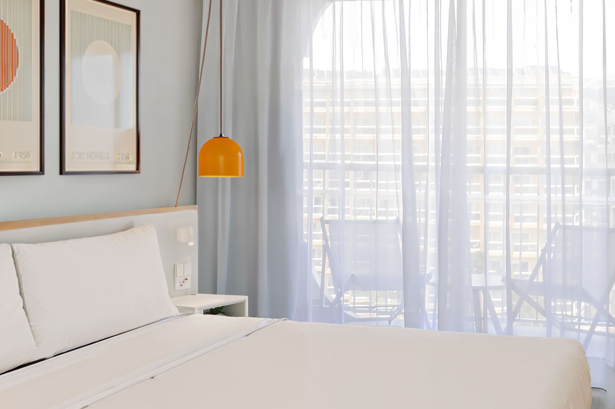 a bed with a lamp and pictures on the wall