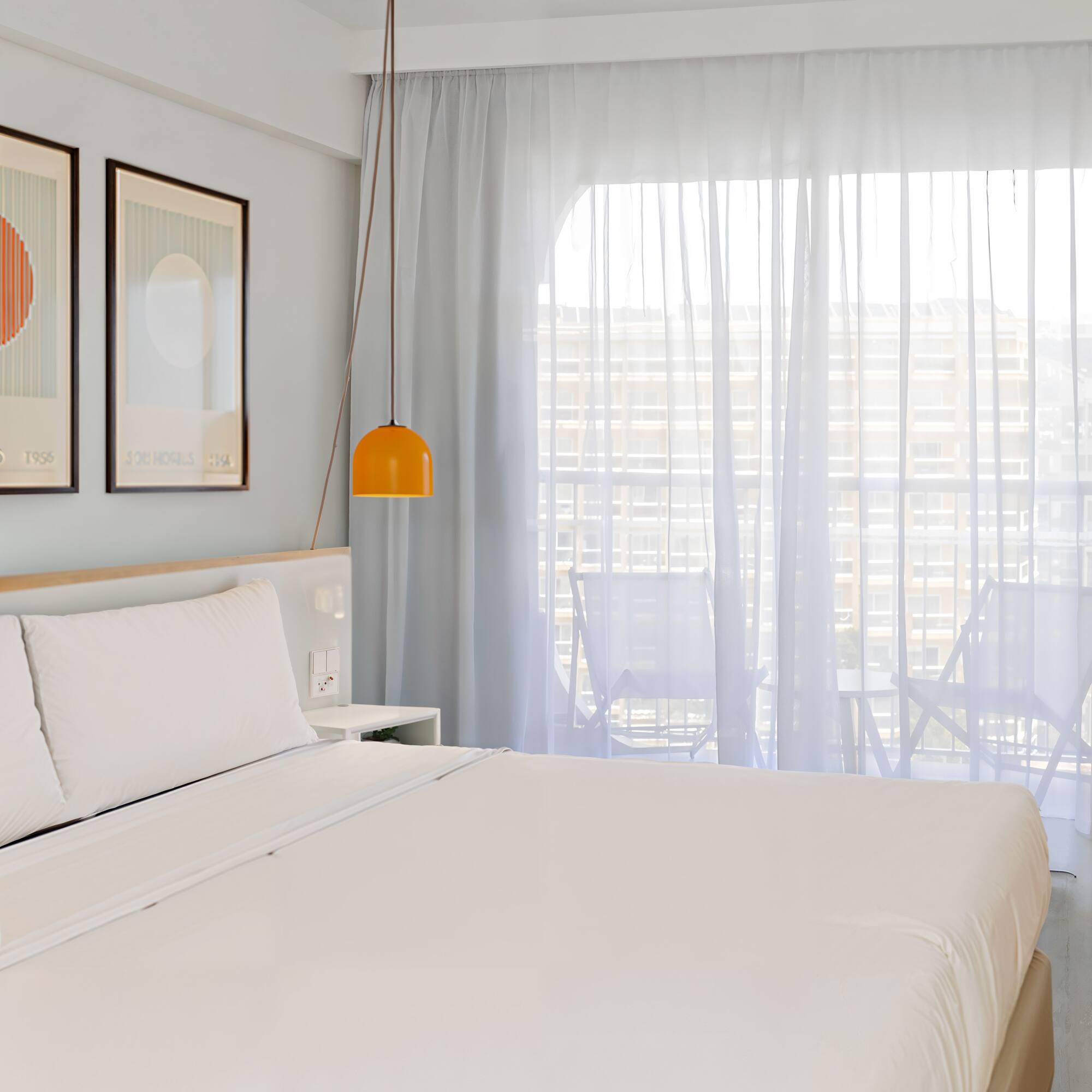 a bed with a lamp and pictures on the wall