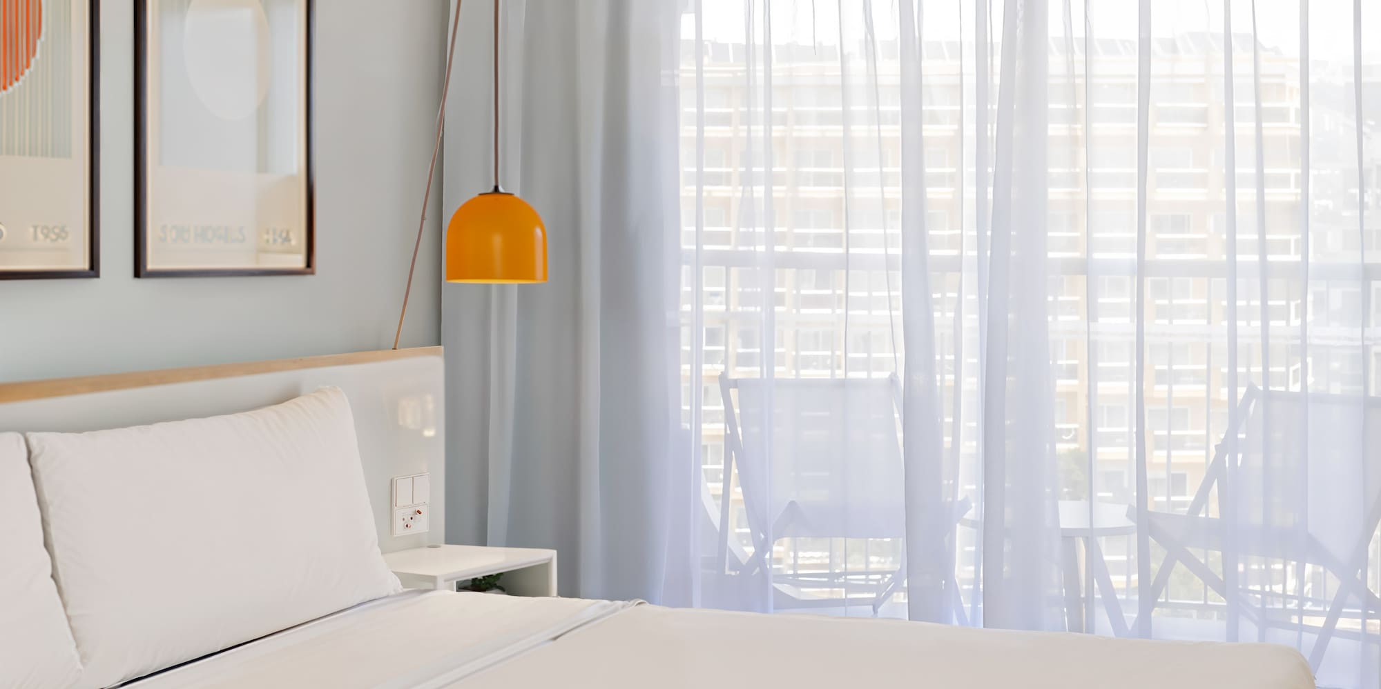 a bed with a lamp and pictures on the wall