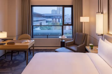 a room with a bed and a table and chairs