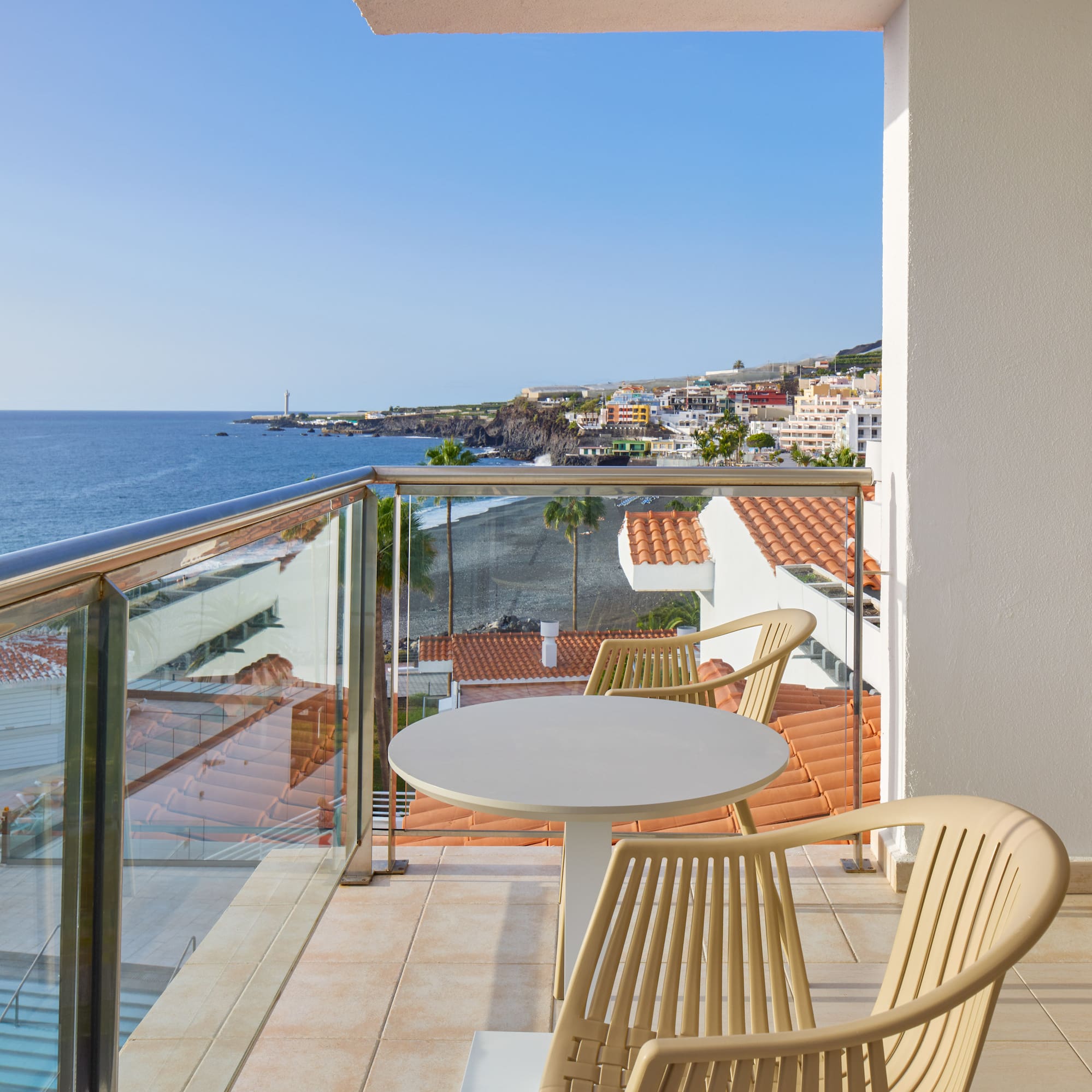 a balcony with a table and chairs overlooking the ocean