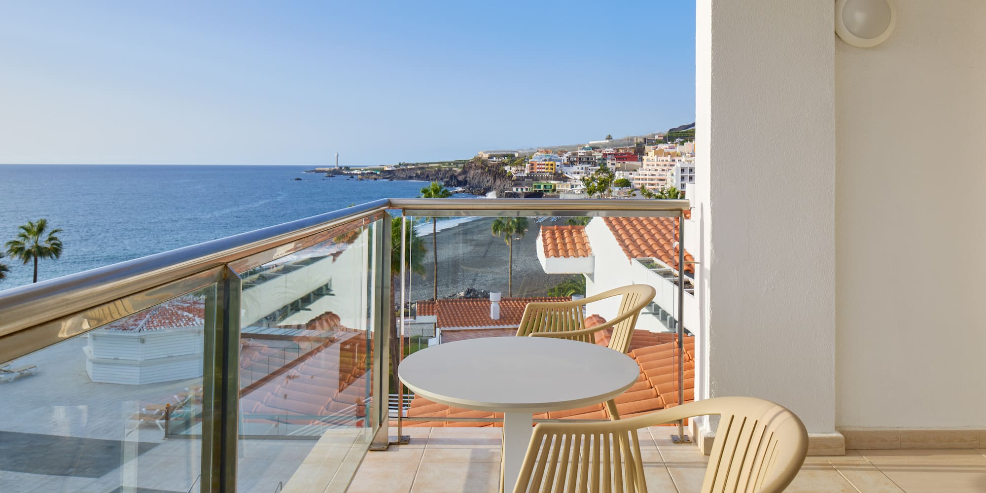 a balcony with a table and chairs overlooking the ocean