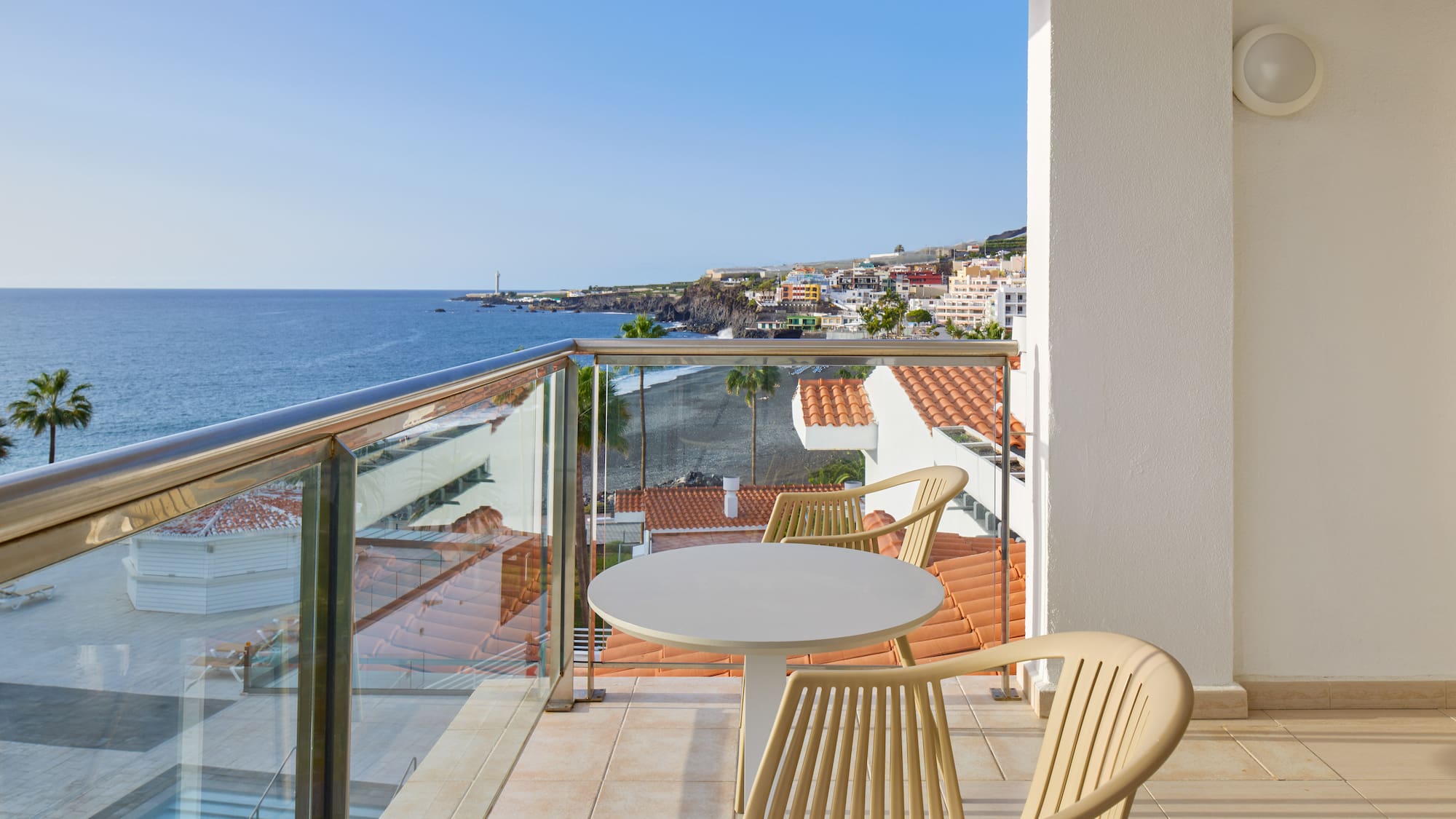 a balcony with a table and chairs overlooking the ocean