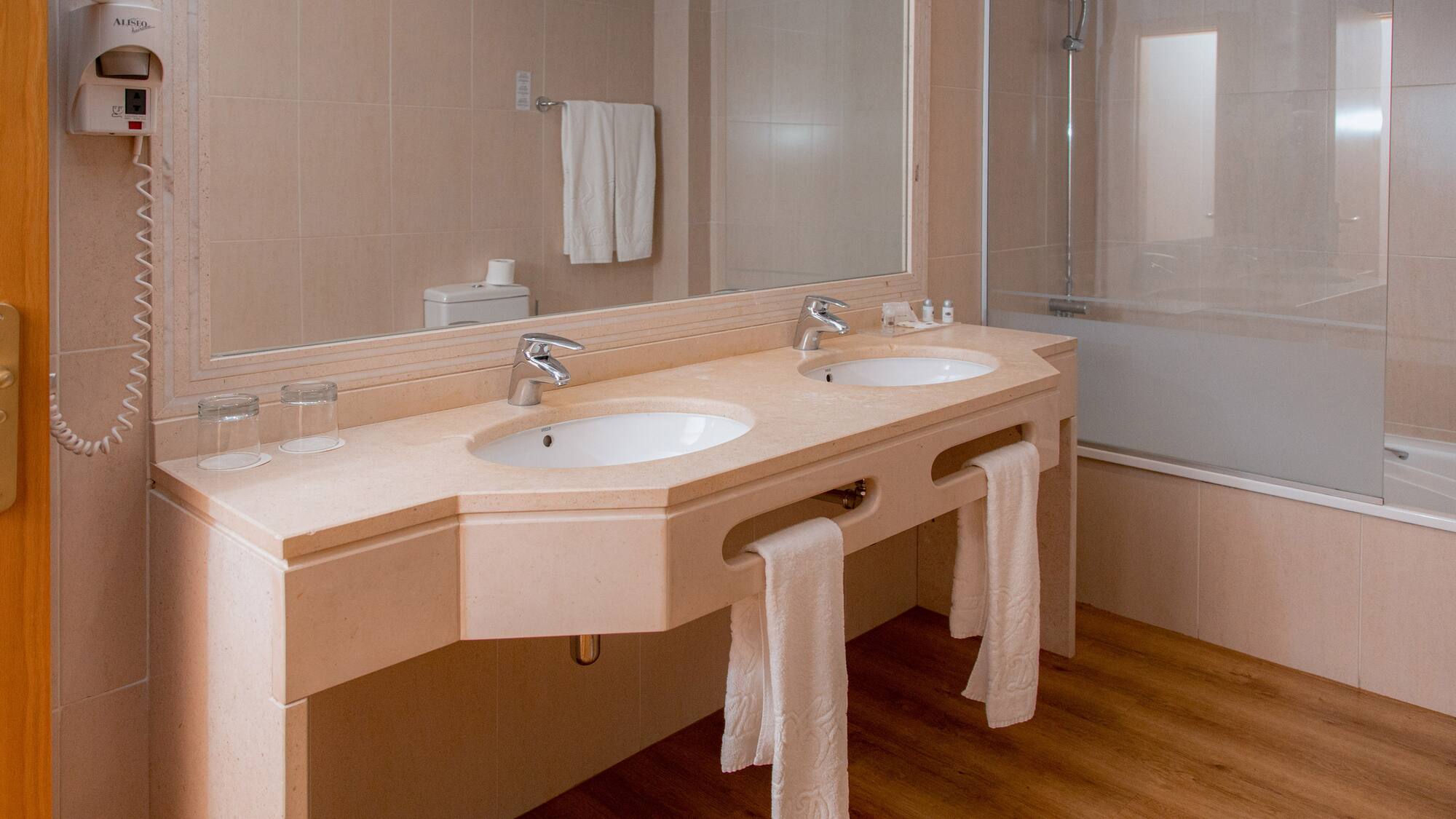 a bathroom with two sinks and a shower