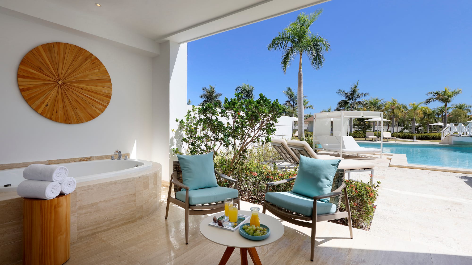 a patio with a hot tub and chairs