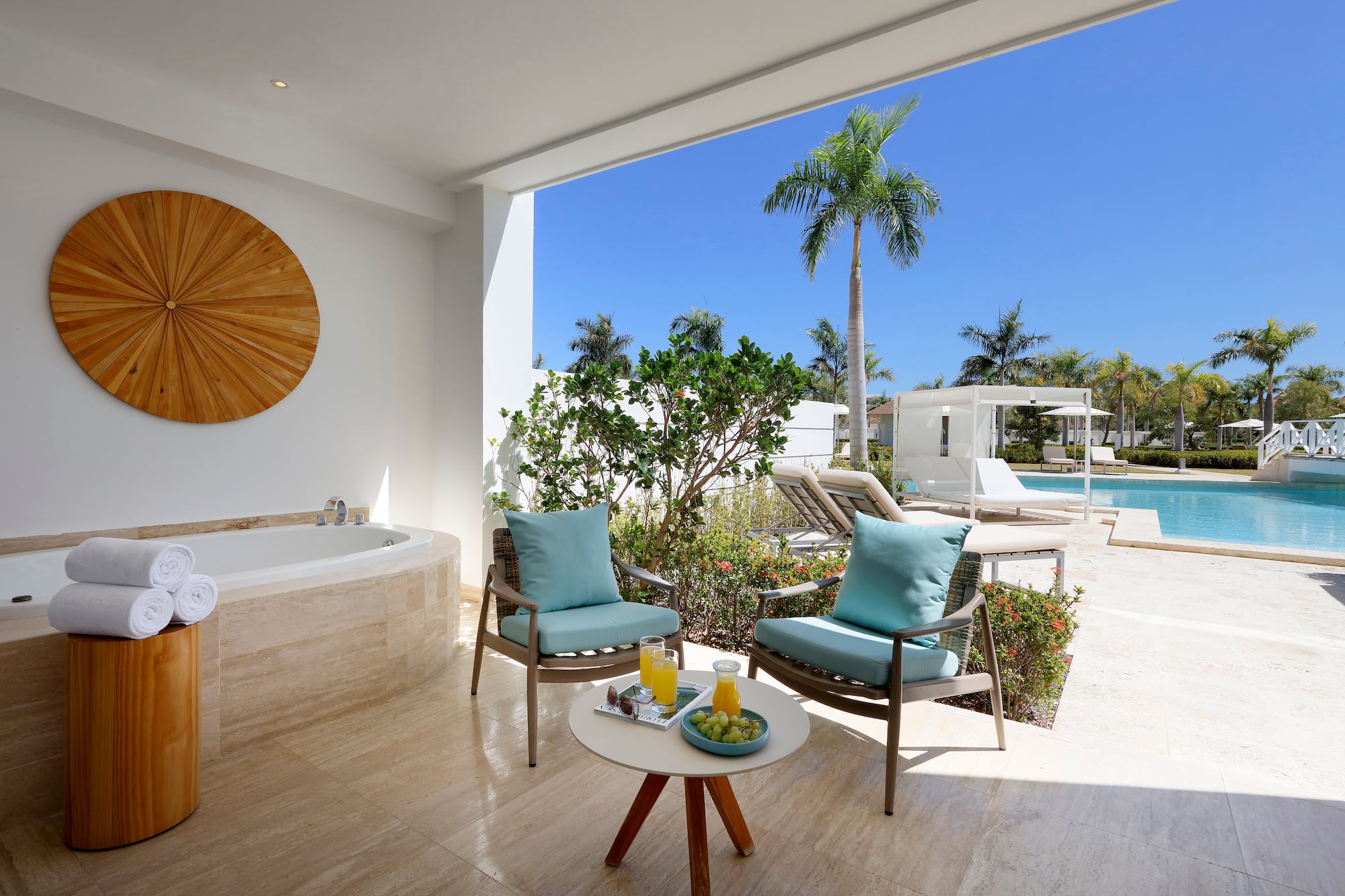a patio with a hot tub and chairs