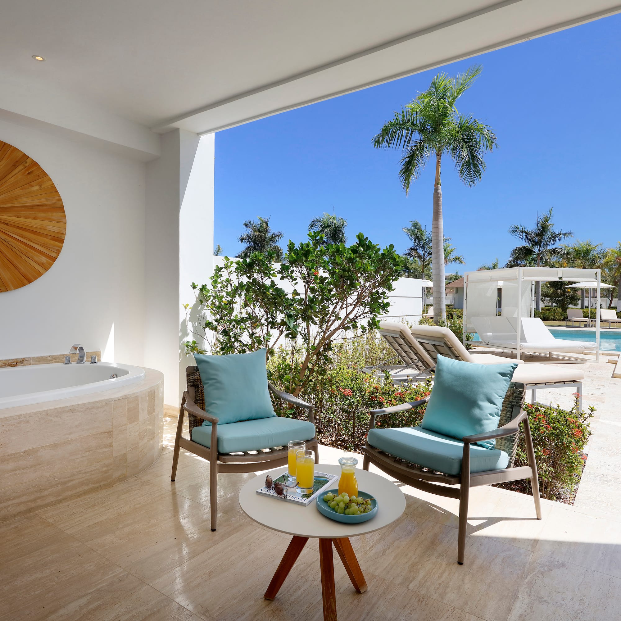 a patio with a hot tub and chairs