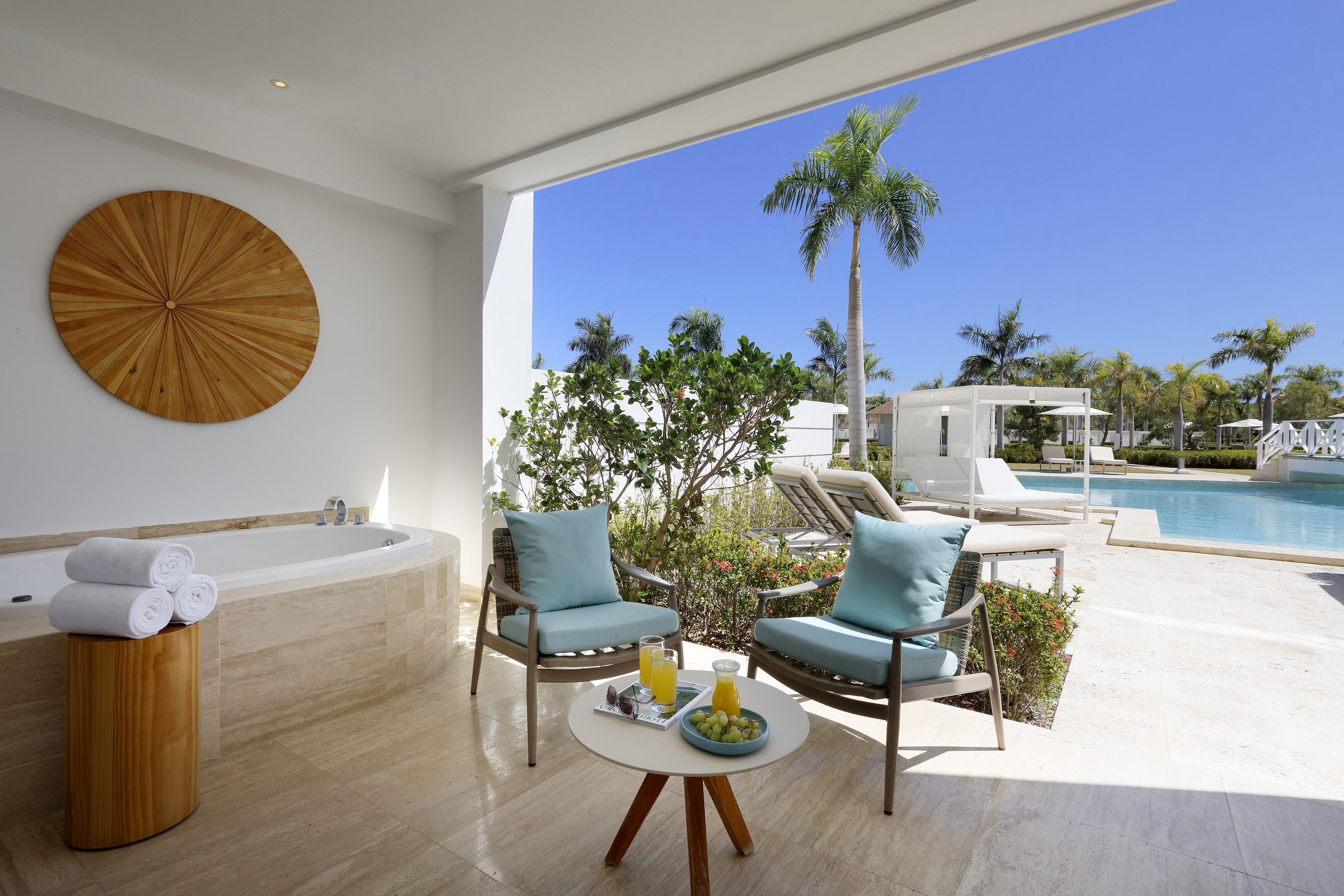 a patio with a hot tub and chairs