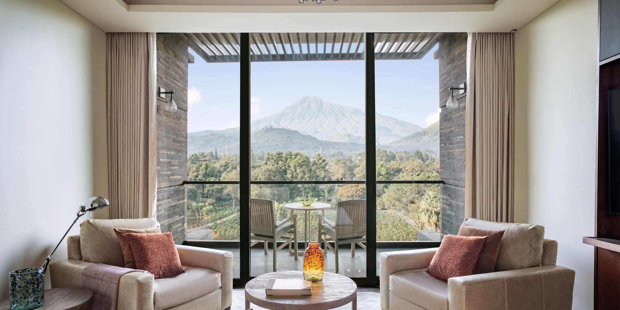 a living room with a view of a mountain and trees