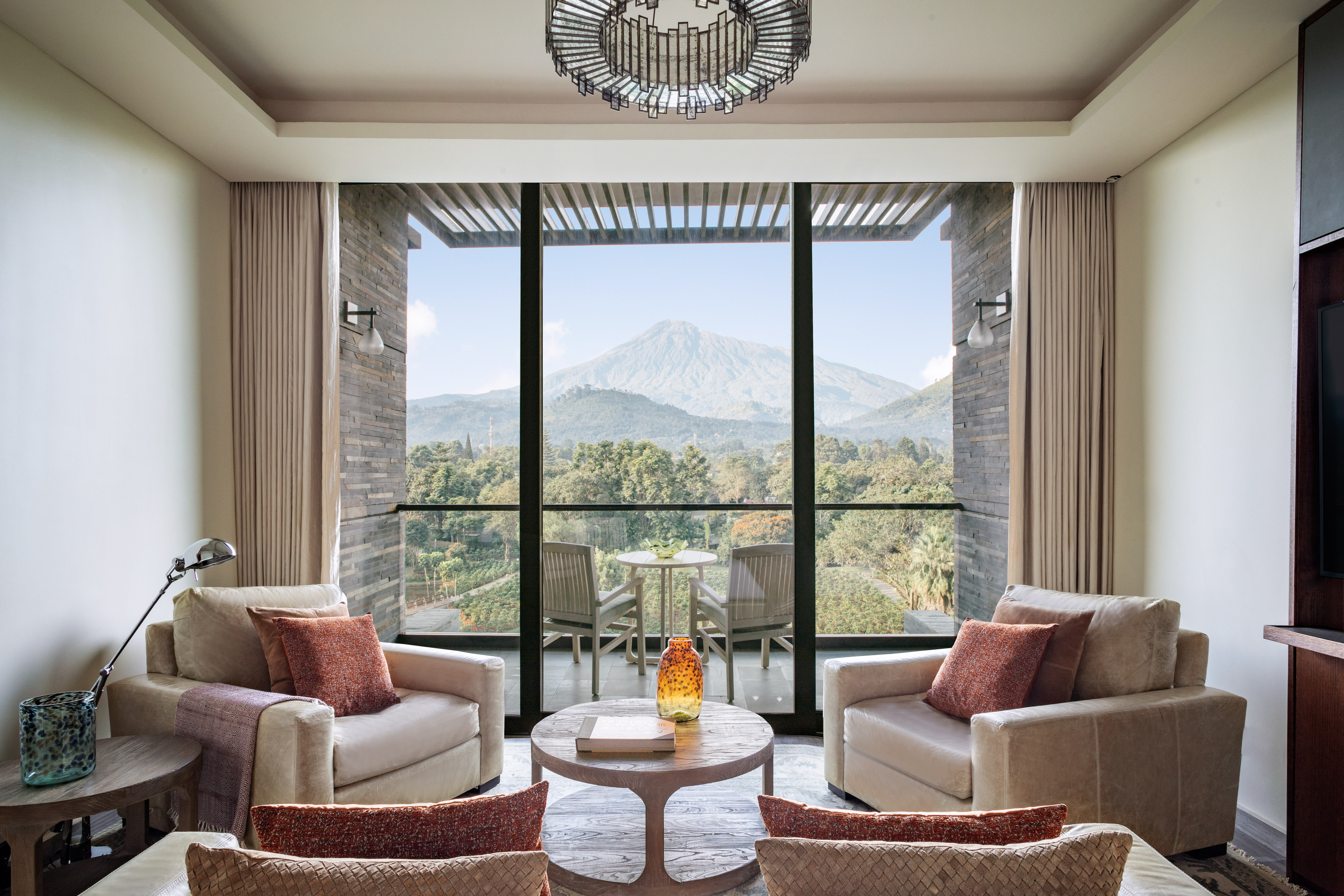 Luxury hotel suite living room with mountain view balcony, modern design.