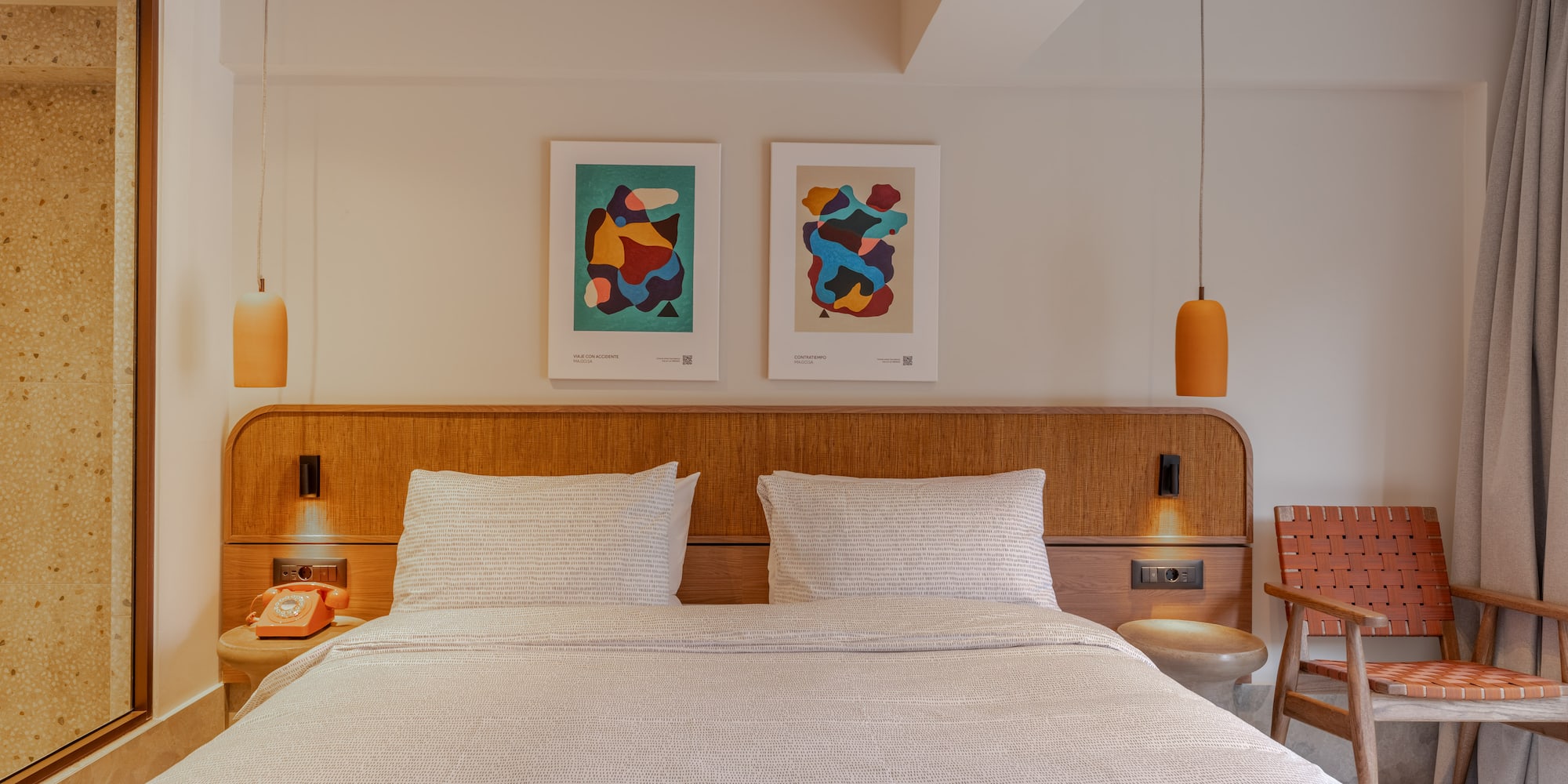 a bed with a wood headboard and two lamps above it