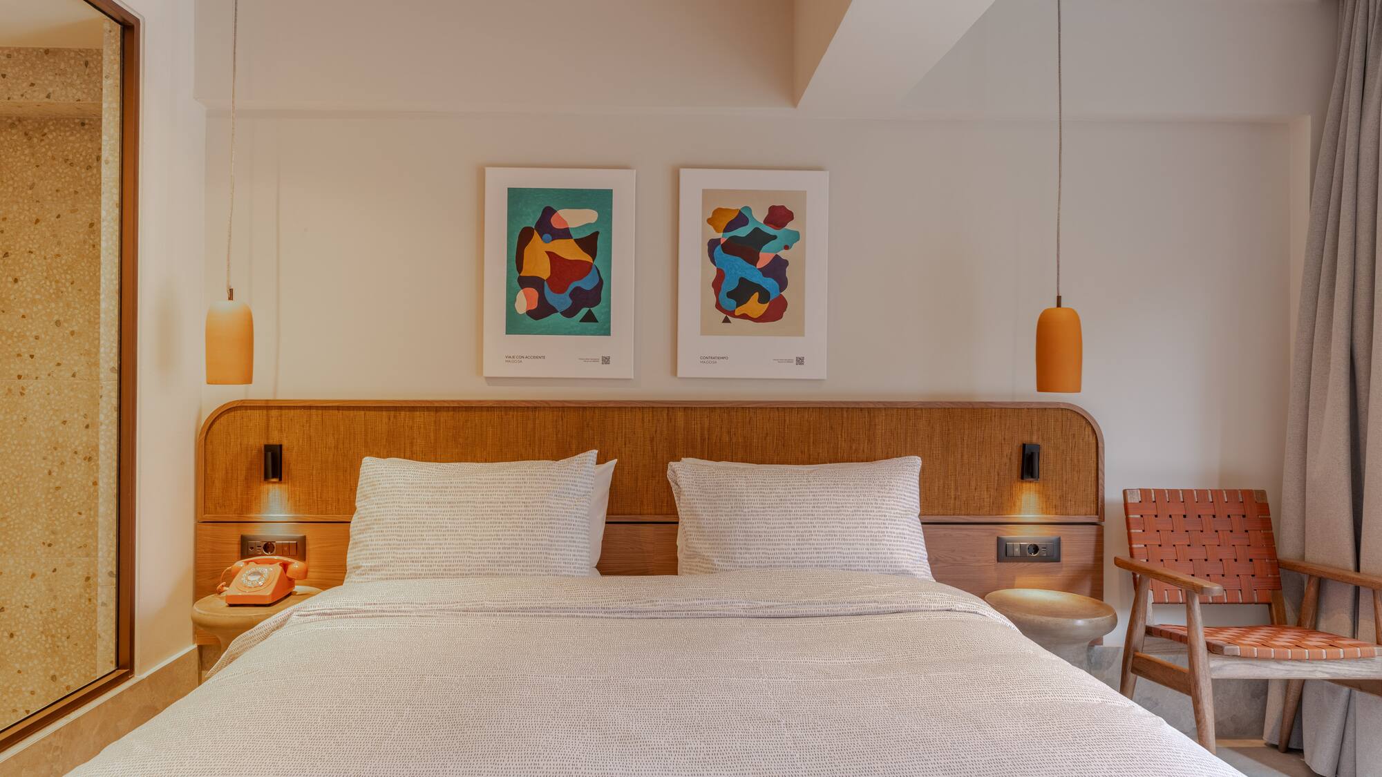 a bed with a wood headboard and two lamps above it