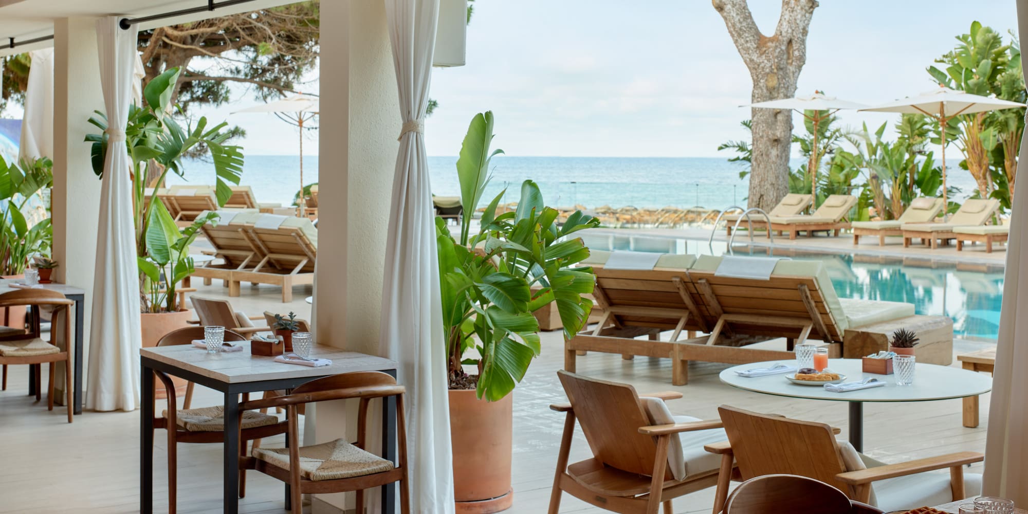 Beachfront restaurant patio overlooking pool and ocean, with outdoor seating.