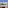 Hotel balcony overlooking turquoise sea, green trees, and distant coastal town.