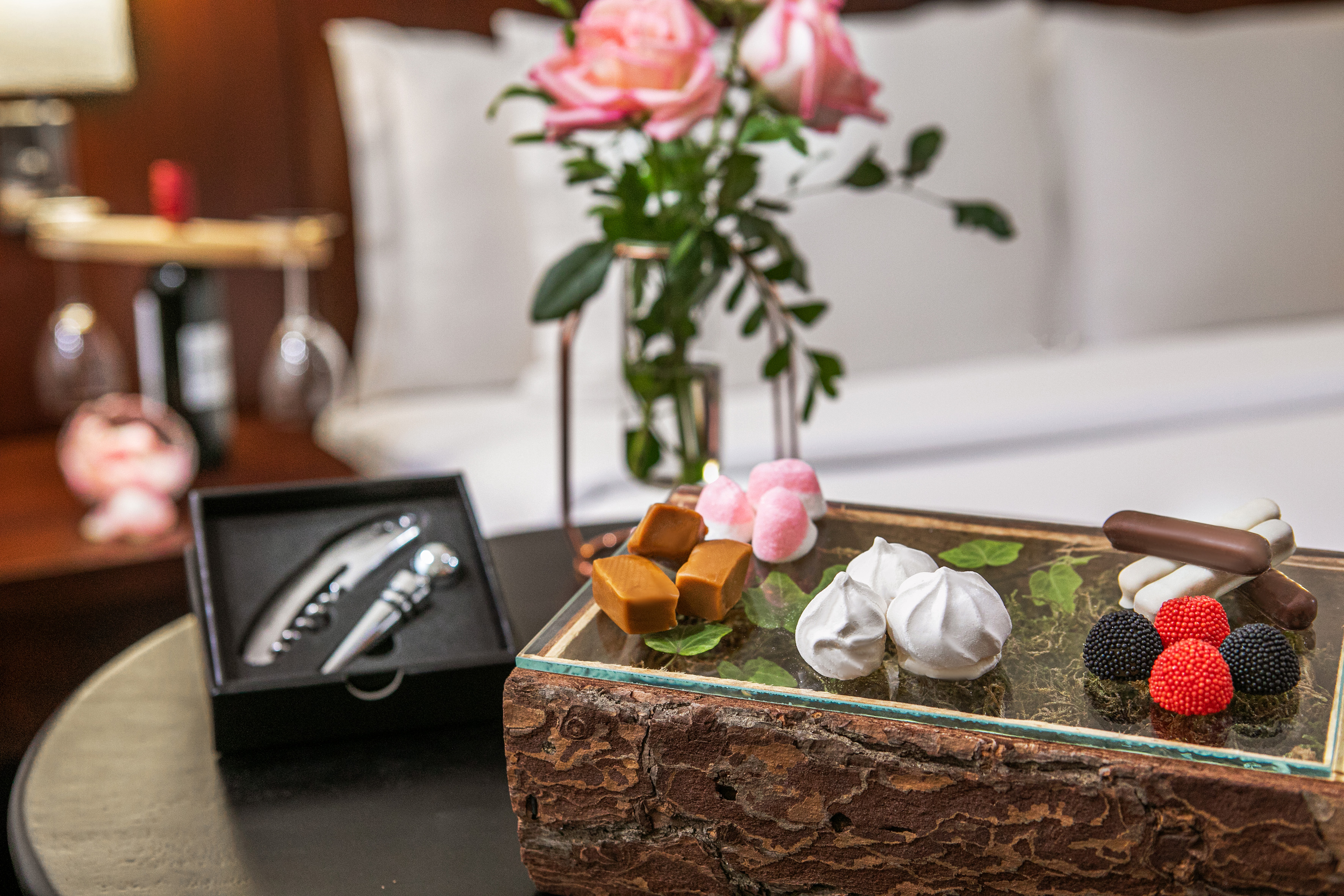 a table with a glass tray with food and a vase of flowers.