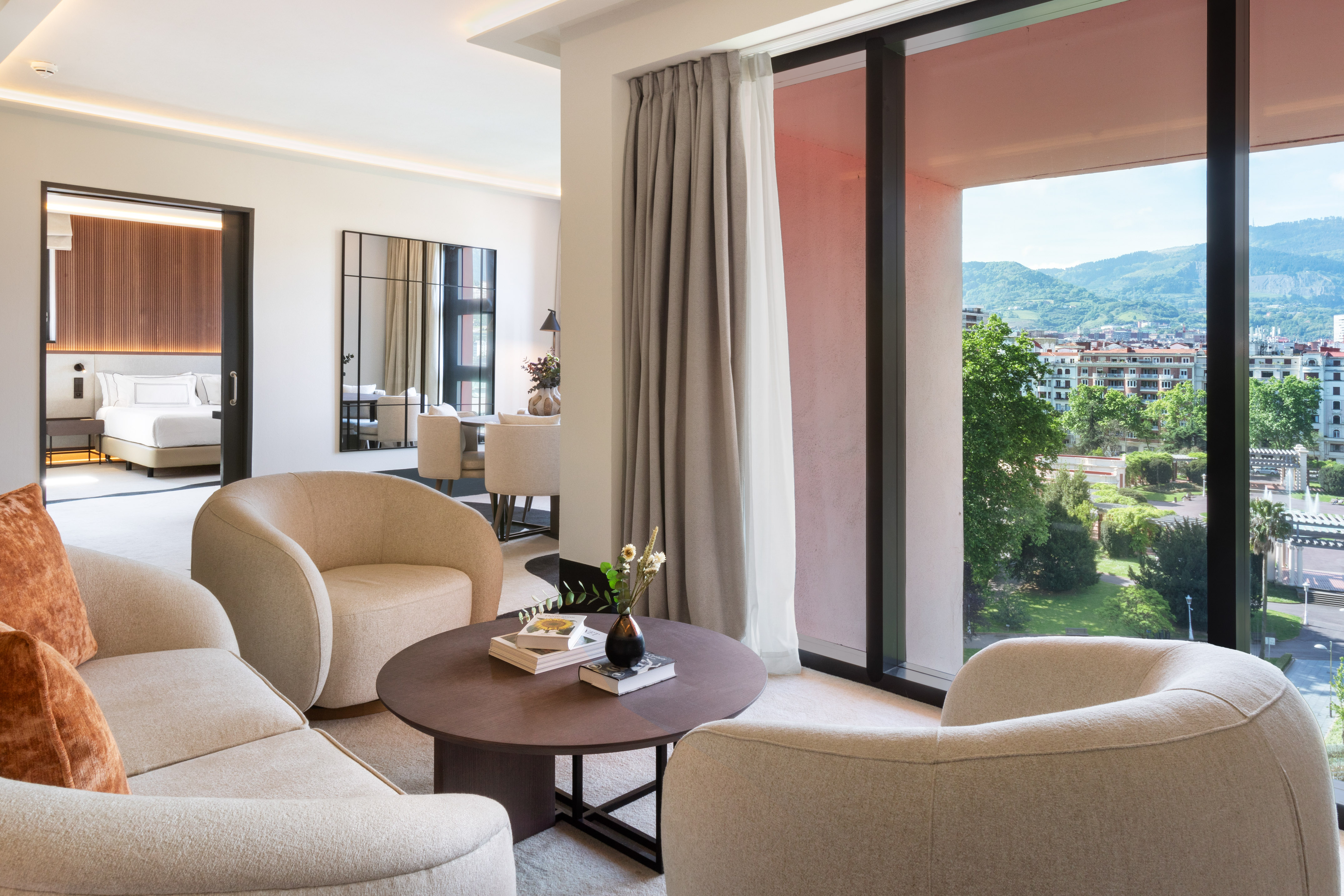 Luxury hotel suite living room with panoramic mountain city view.