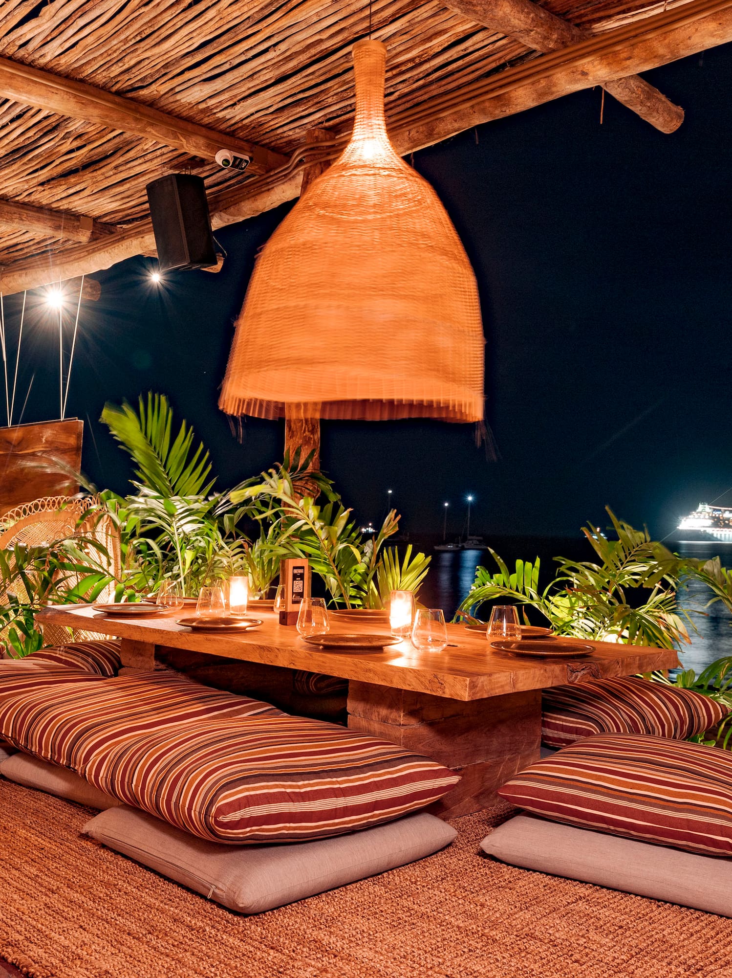 a table with pillows and a lamp on a wooden surface