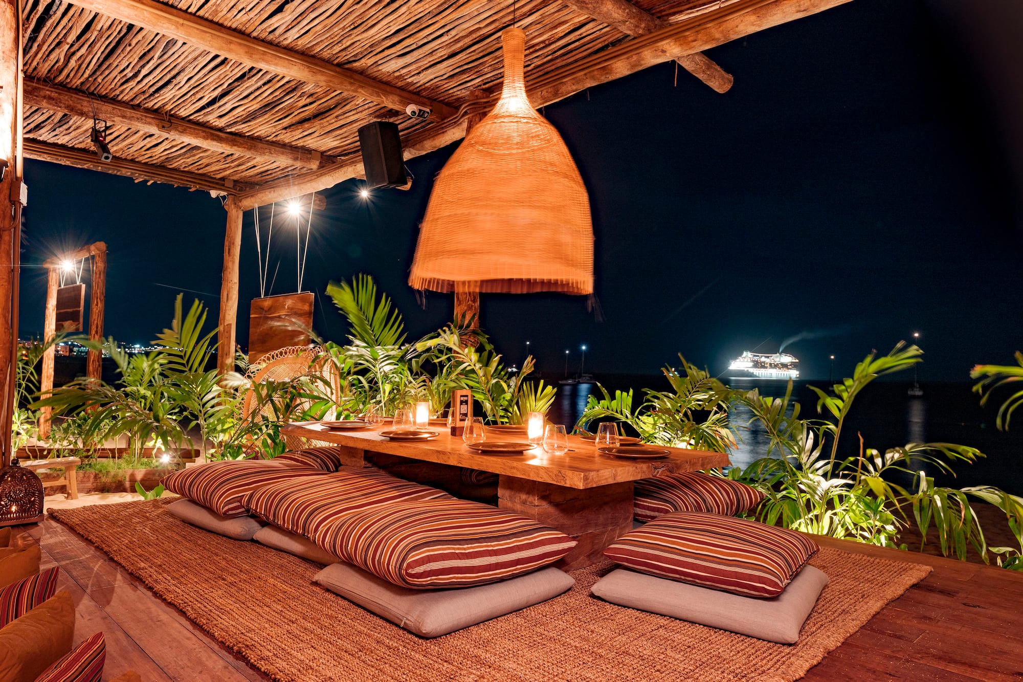 a table with pillows and a lamp on a wooden surface