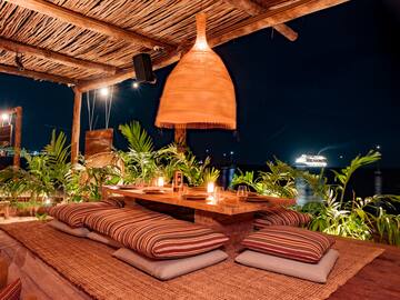 a table with pillows and a lamp on a wooden surface