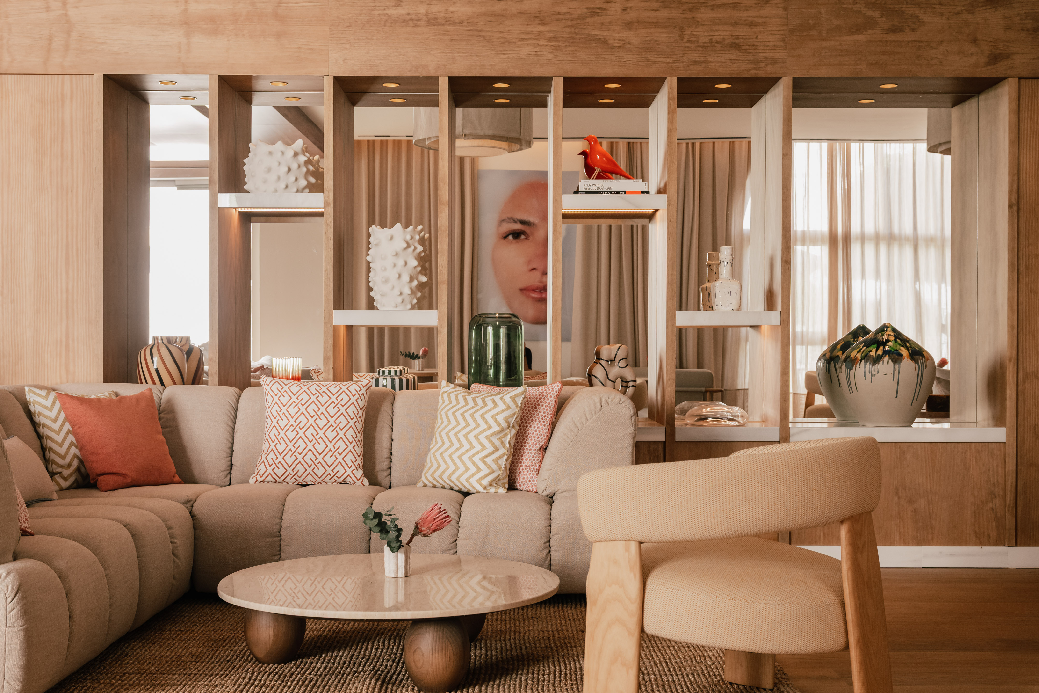 Contemporary living room with beige sofa, wood shelves displaying modern decor.