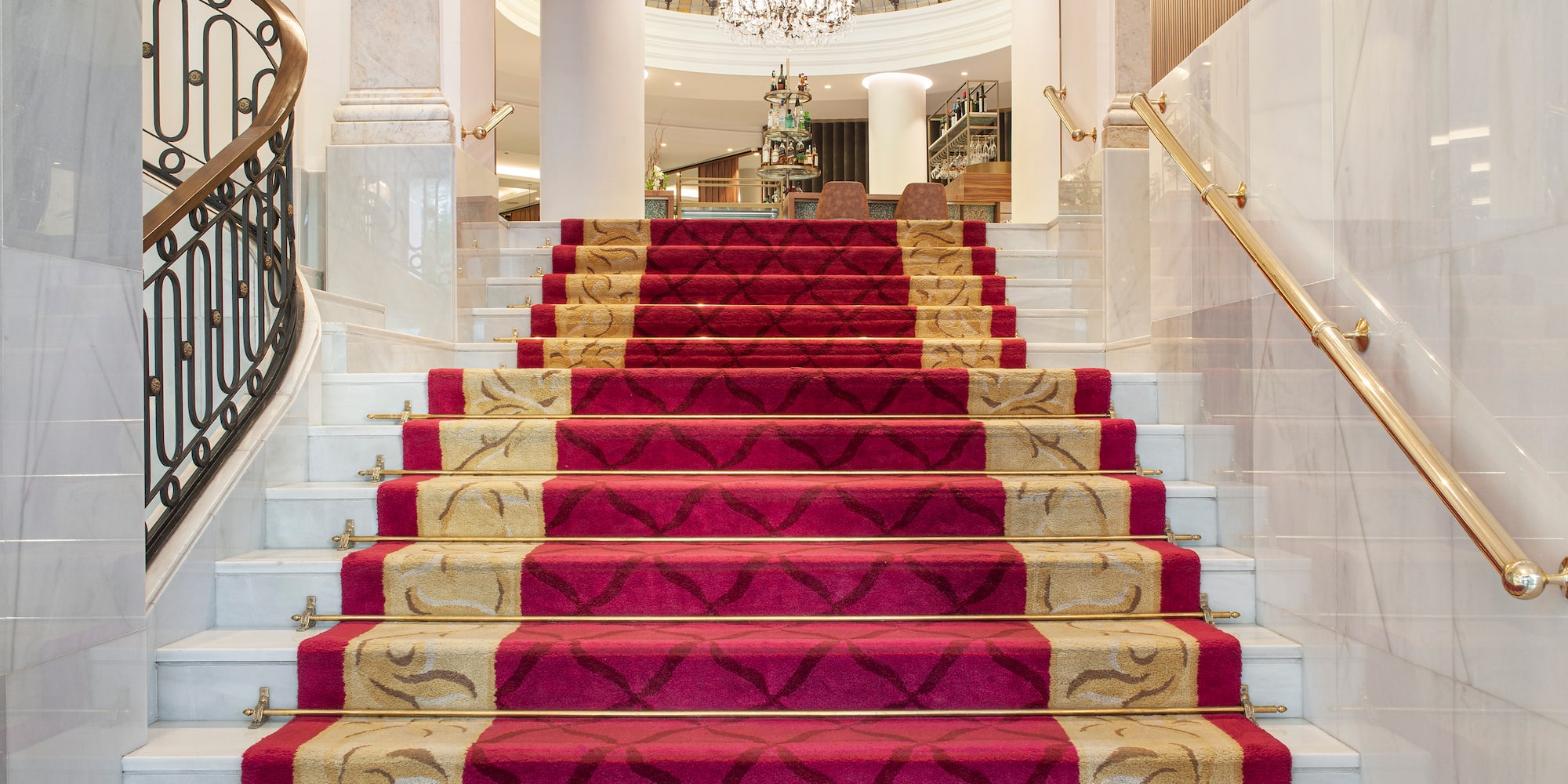 a staircase with red carpet and gold railings