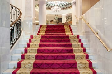 a staircase with red carpet and gold railings