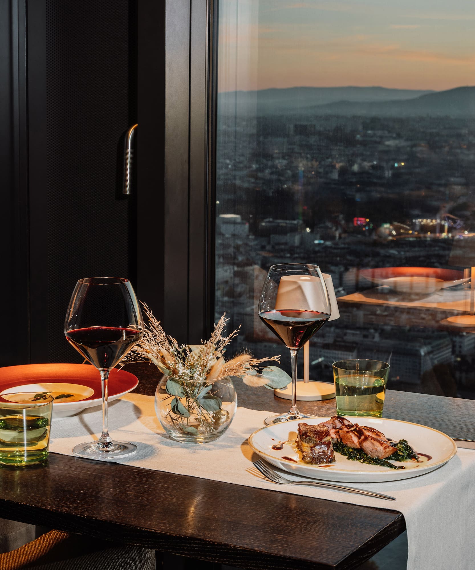 a table with plates of food and wine glasses on it