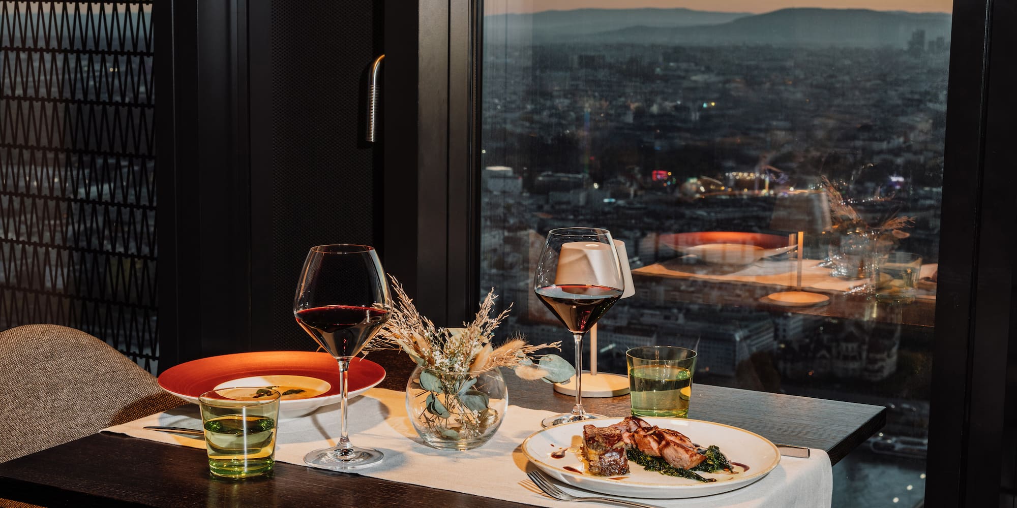 a table with plates of food and wine glasses on it