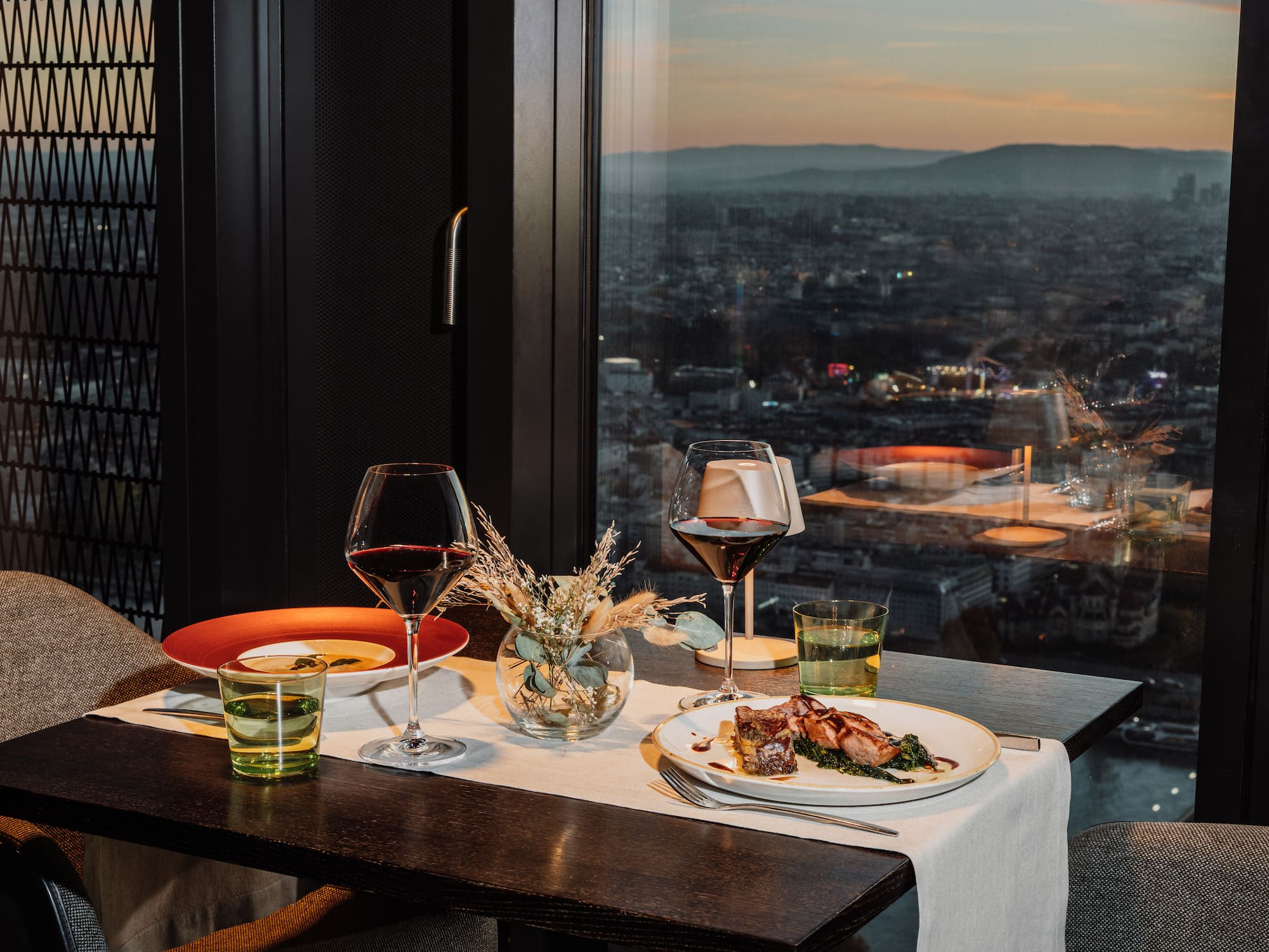 a table with plates of food and wine glasses on it