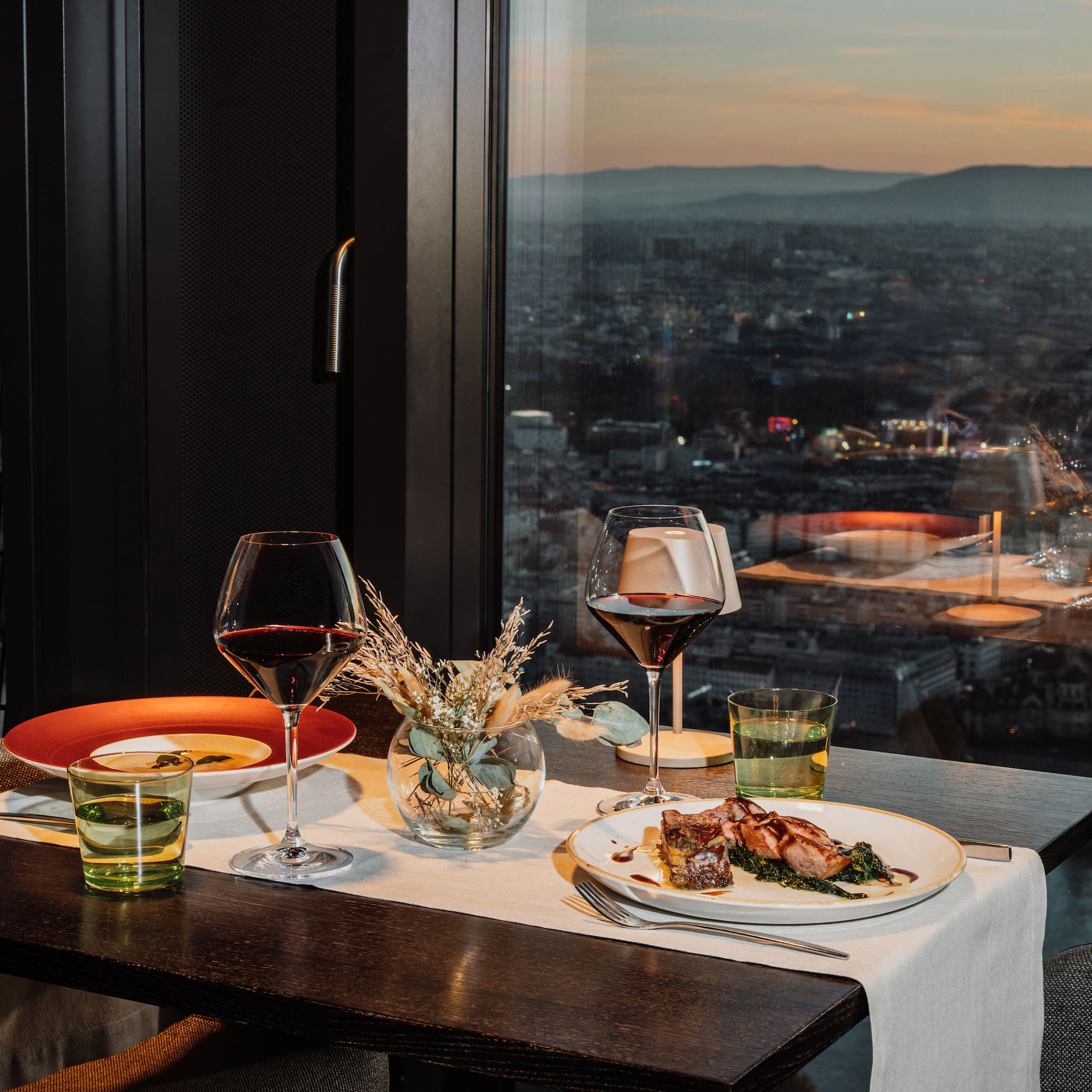 a table with plates of food and wine glasses on it