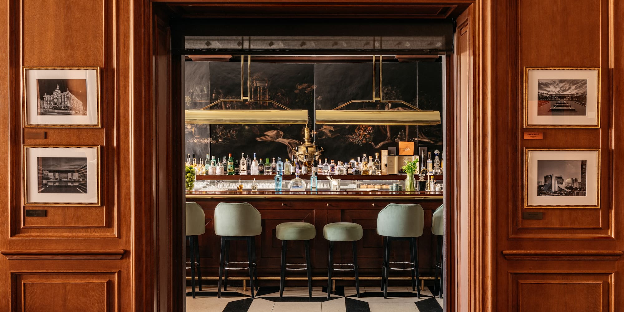 a bar with chairs and bottles in front of it