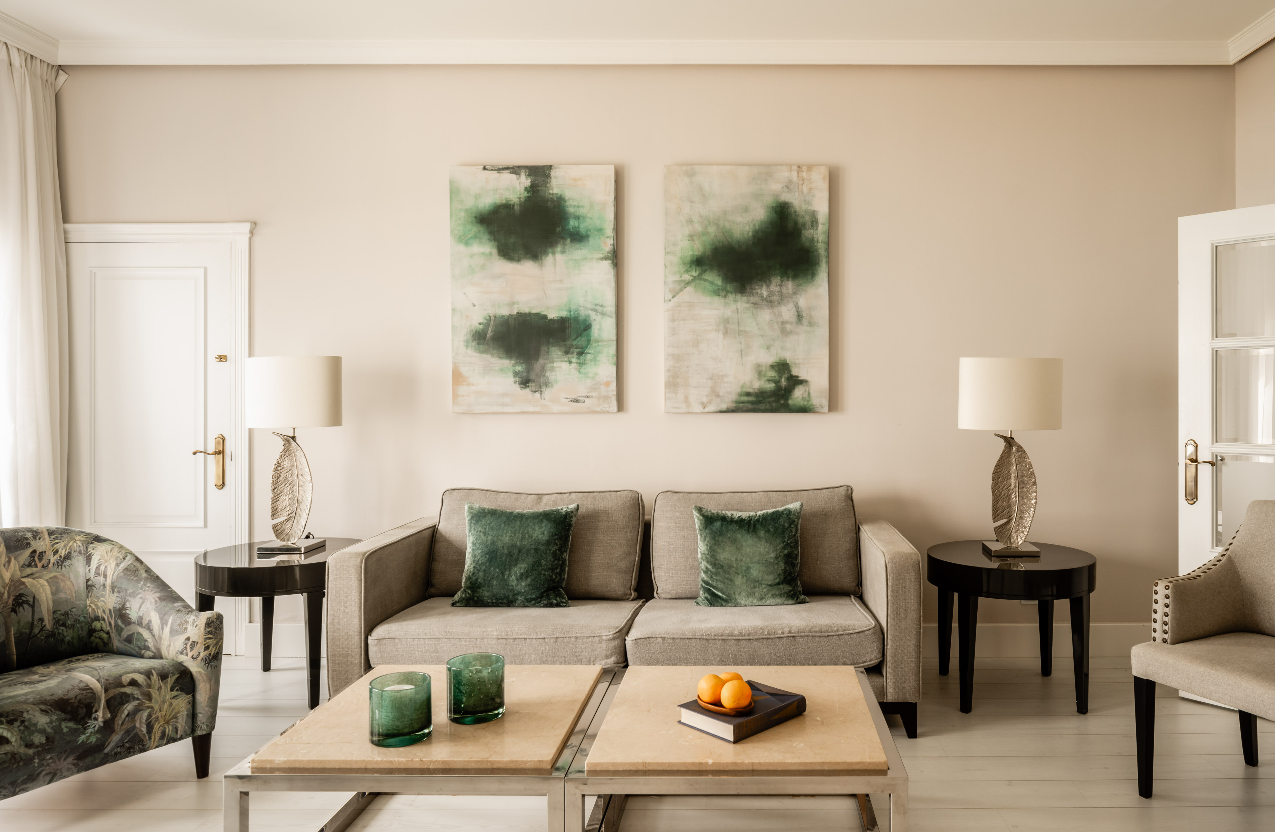 Elegant living room with gray sofa, abstract green art, and modern decor.