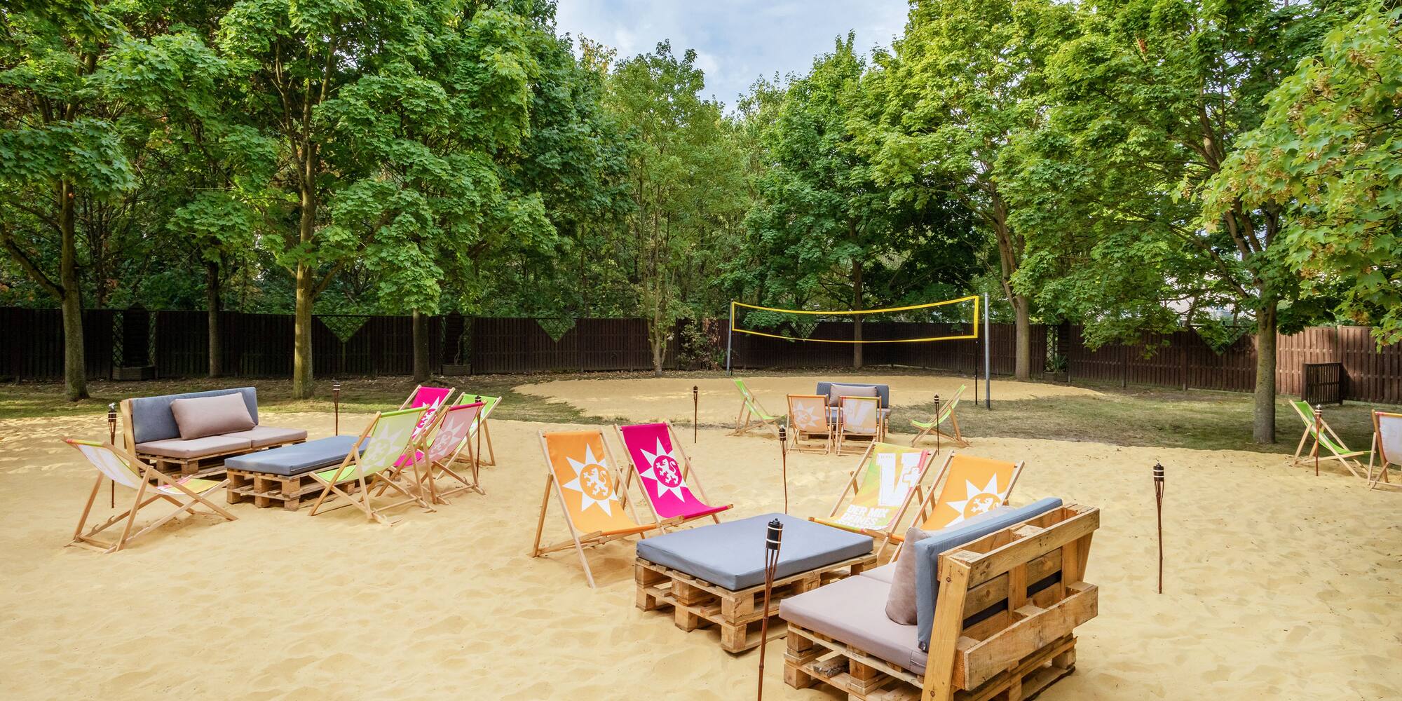 a beach volleyball net and chairs on sand