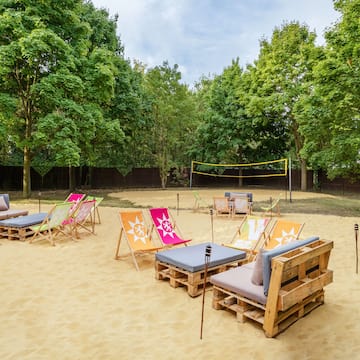 a beach volleyball net and chairs on sand