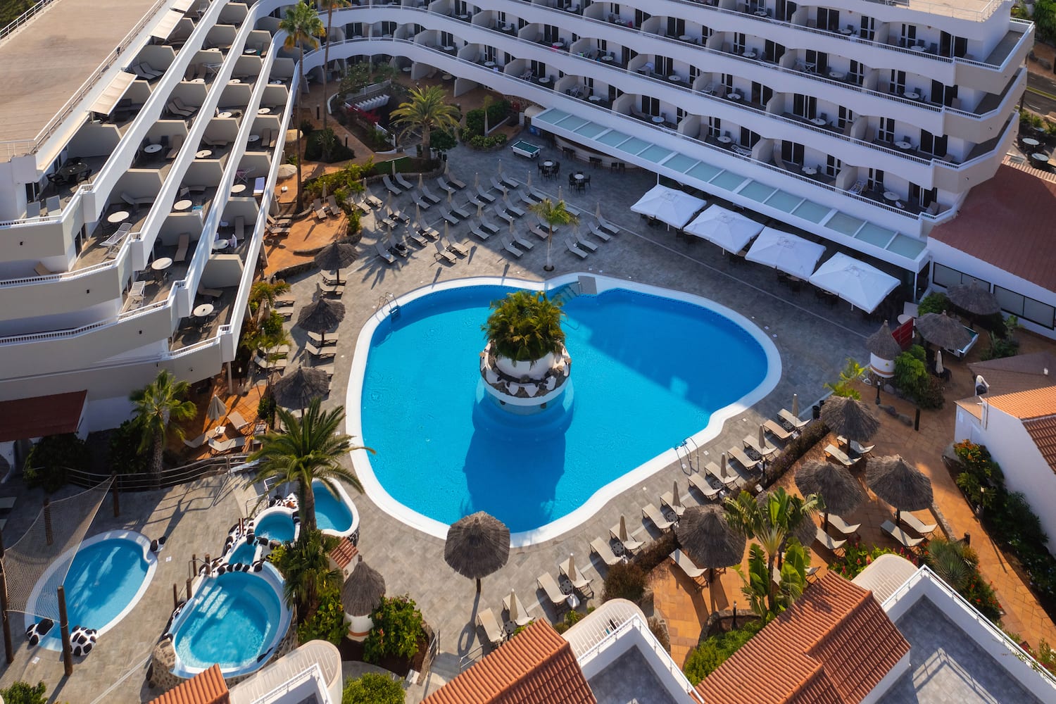 a pool with a tree in it surrounded by buildings