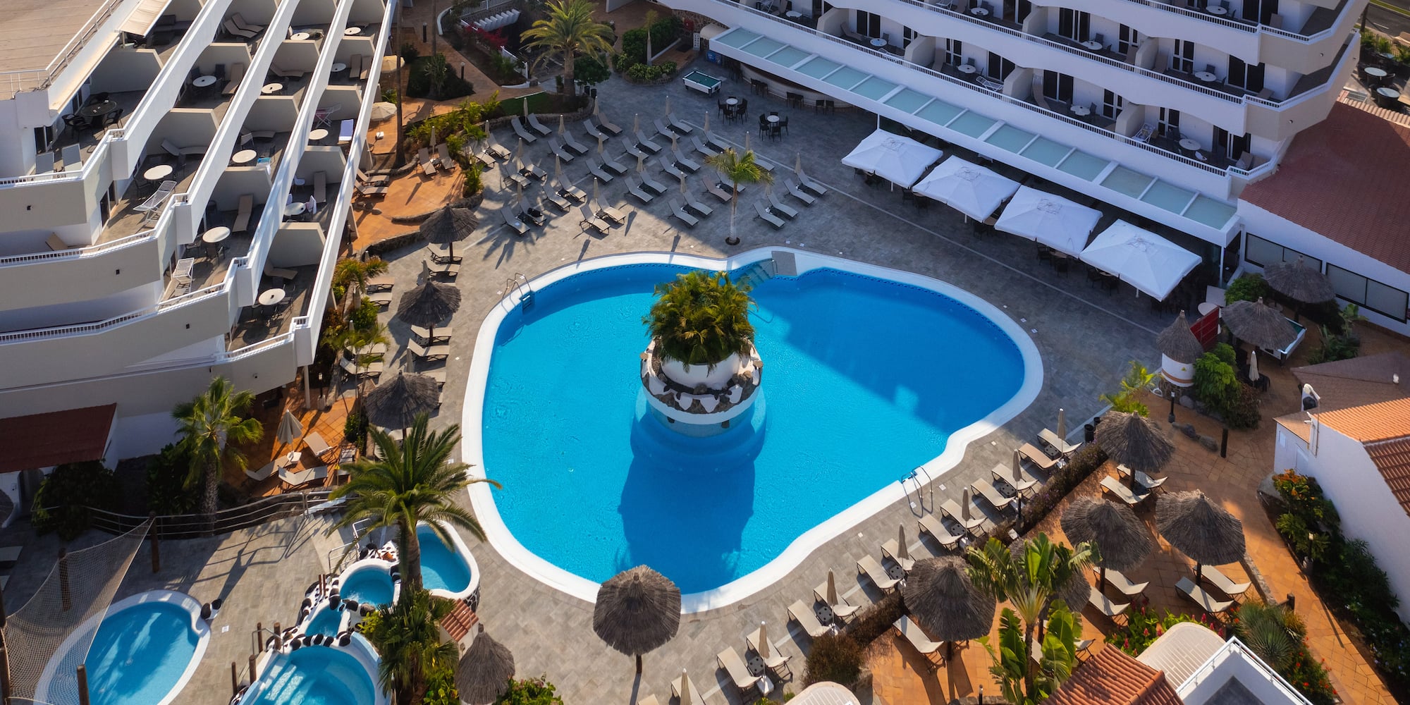 a pool with a tree in it surrounded by buildings