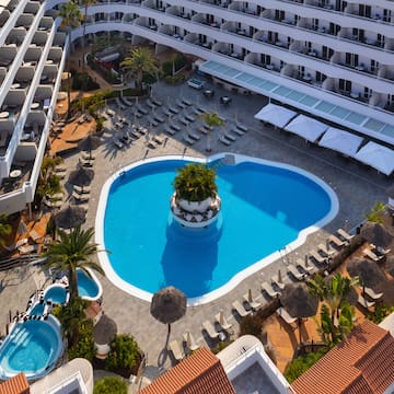 a pool with a tree in it surrounded by buildings